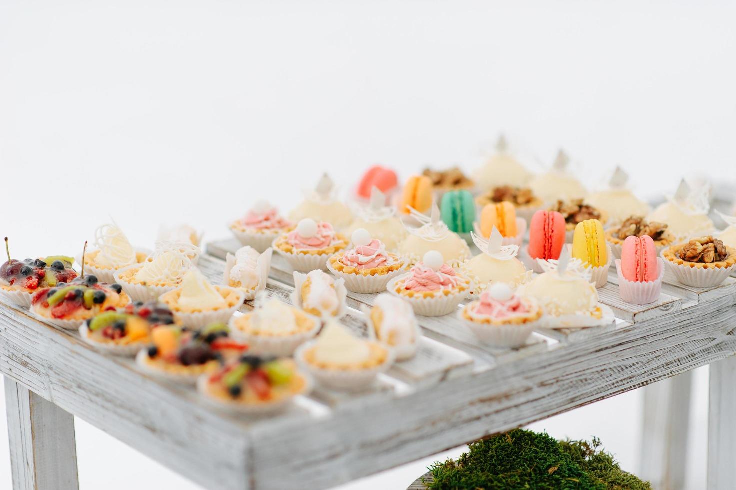 Vielfalt an leckeren, appetitlichen süßen Desserts mit Sahne, Beeren und Gebäck, Backwaren und Kuchen auf dem großen Hochzeitstisch zum Feiern foto