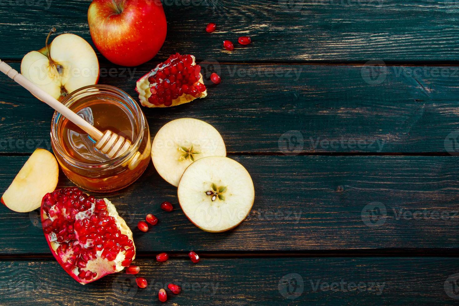 Frohes Rosch Haschana. jüdischer traditioneller religiöser feiertag. äpfel, granatäpfel und honig auf dunklem holzhintergrund. Platz für Ihren Text. foto