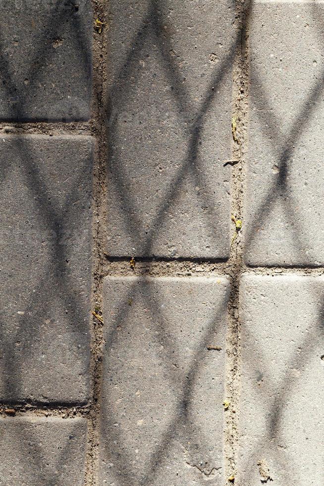 Schatten auf einer Straßenplatte foto