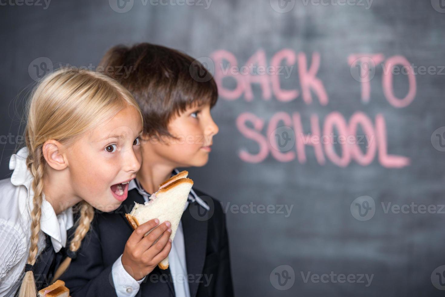 lustiges Bild von Schuljungen und -mädchen mit Sandwiches foto