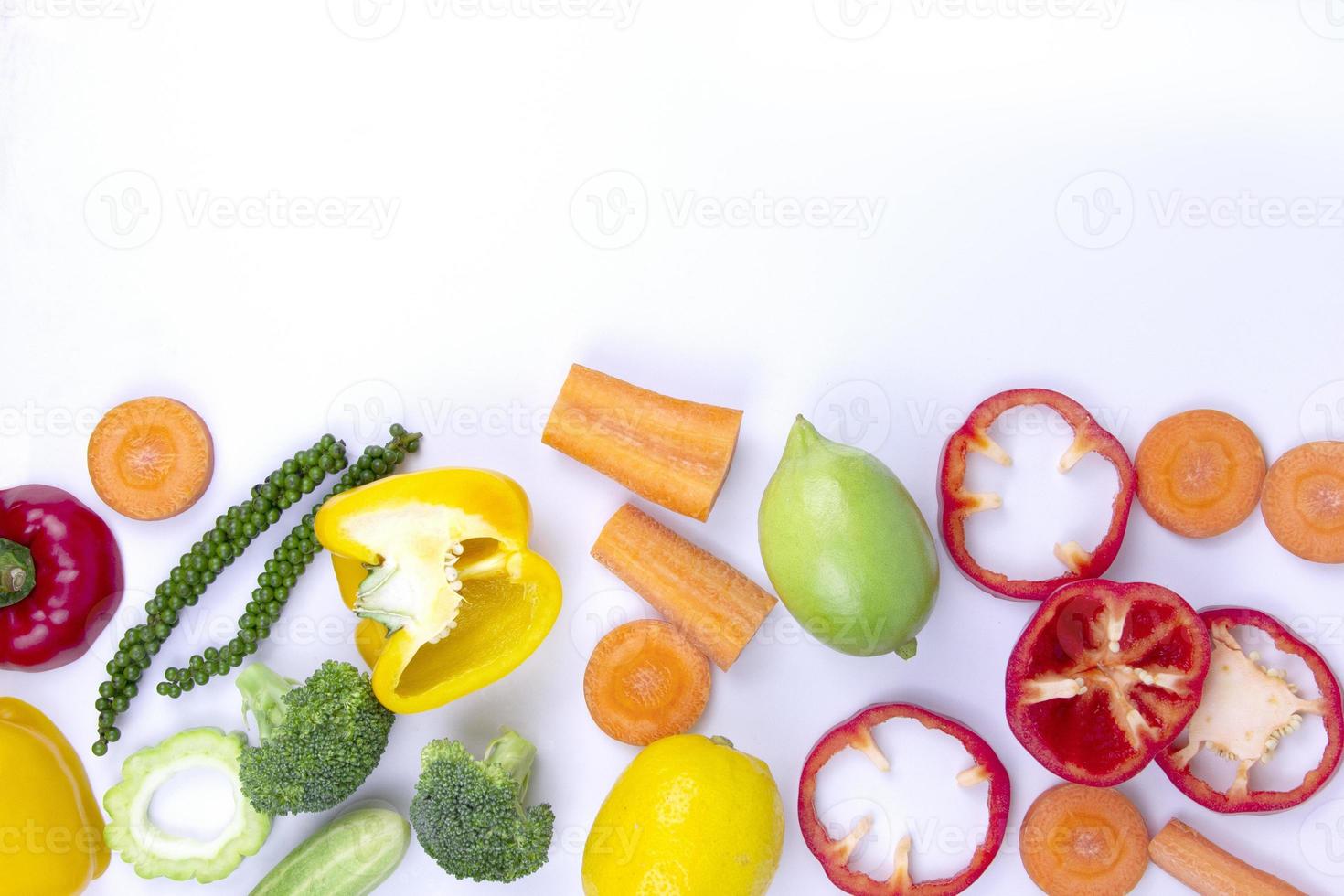 frische früchte isoliert auf weißem hintergrund, gesundes essen in verschiedenen schnitten von brocerlis, karotten, zitronen, kürbis, süßer paprika und mit tempo für die textbeschreibung foto