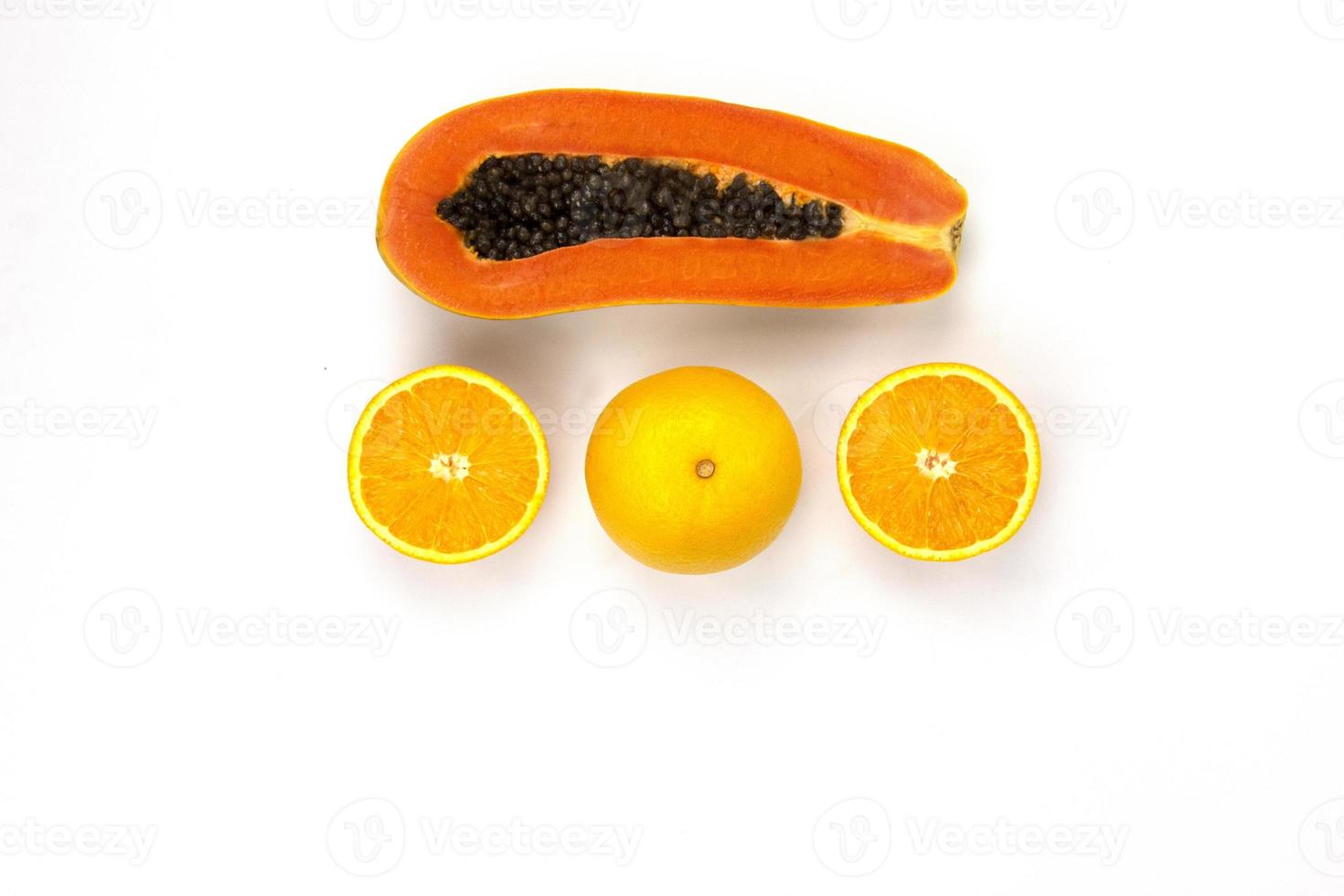 saftige orangen geschnitten isoliert und ein stück papaya in scheiben geschnitten in der mitte des weißen hintergrunds angeordnet, gesunde fruchtfotografiekonzepte, draufsichtdesign foto