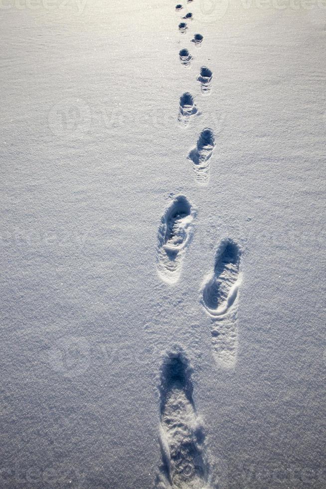 Fußspuren auf Schneeverwehungen nach dem Gehen foto