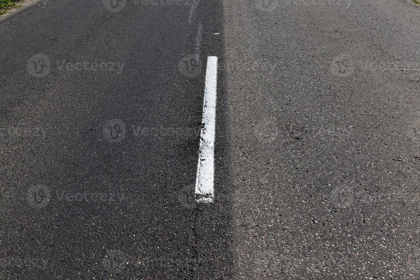 asphaltierte straße mit weißen straßenmarkierungen für das transportmanagement foto