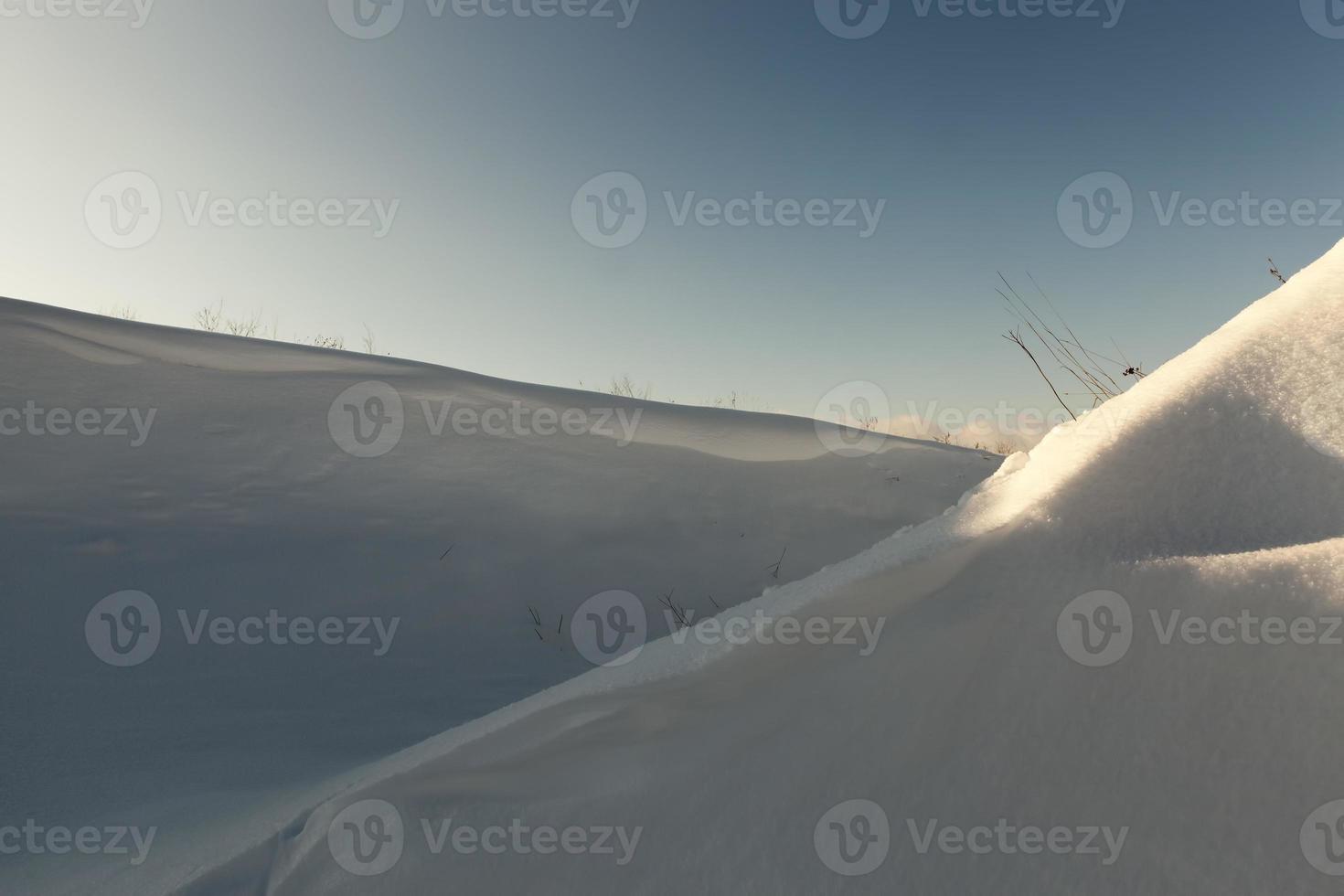 Bedeckter Boden und Gras mit einer dicken Schneeschicht nach einem Zyklon foto