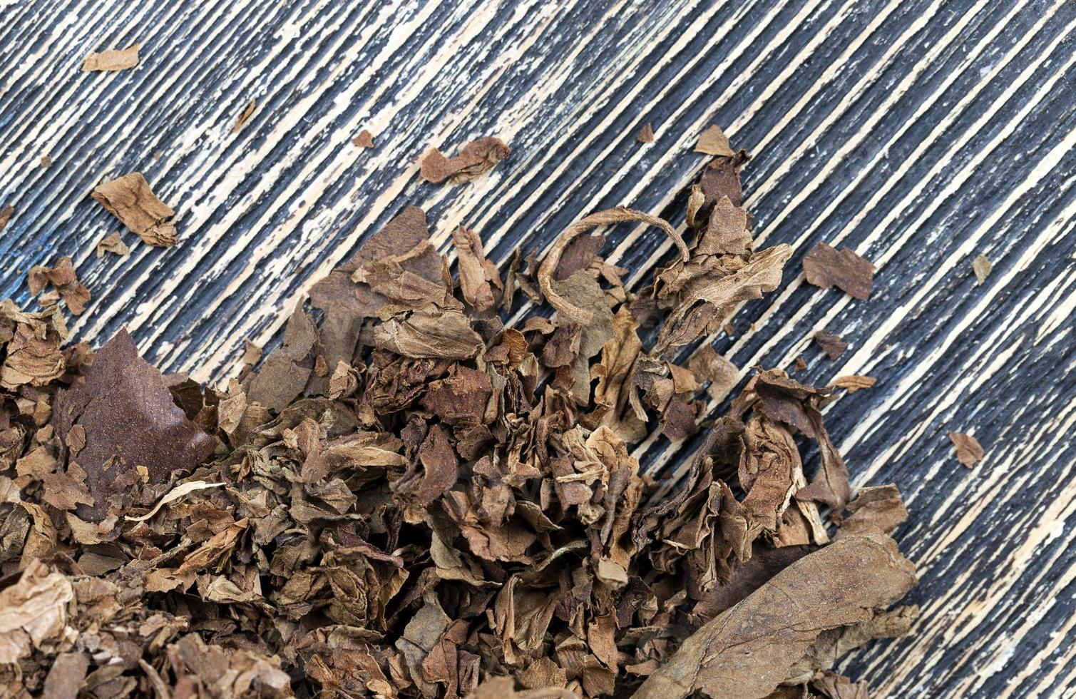 Tabak von einer zerbröckelnden Zigarette auf dem Brett foto