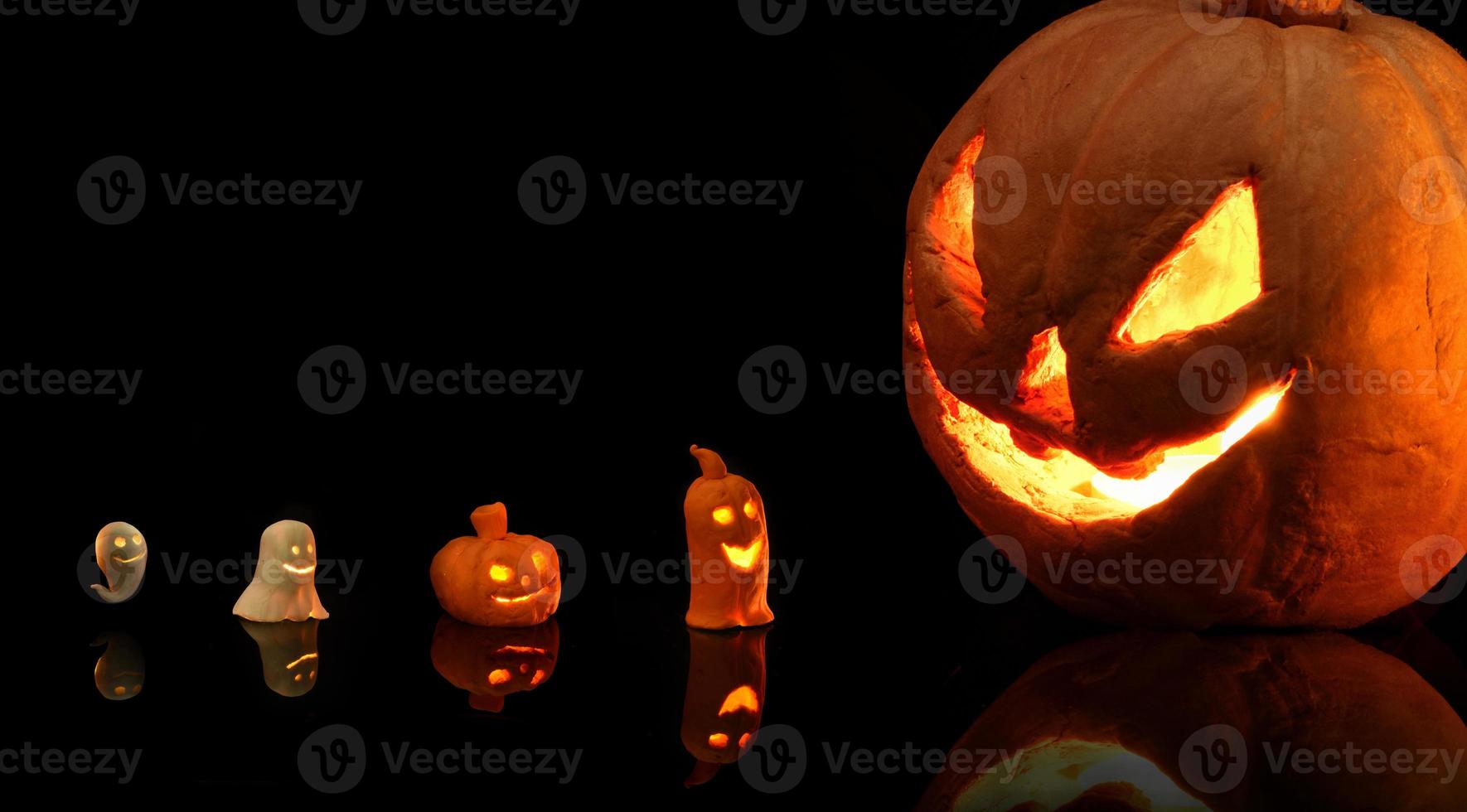 Halloween-Kürbis mit brennenden Kerzen auf schwarzem Hintergrund foto