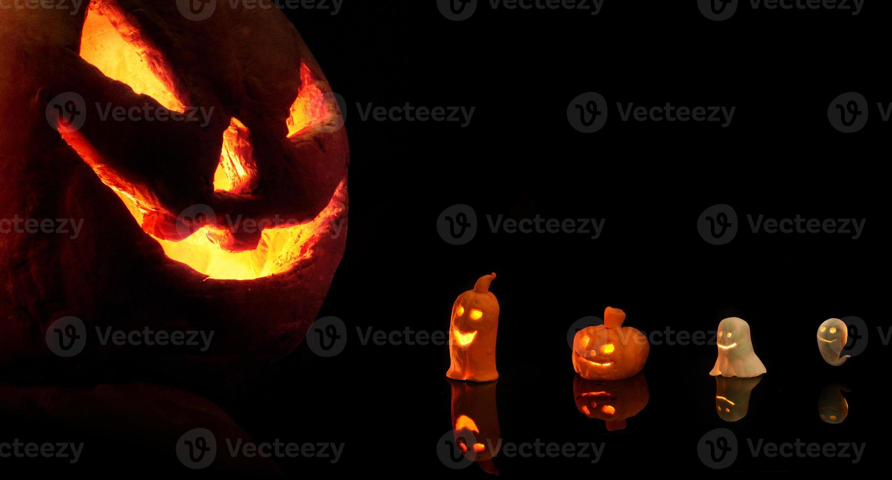 Halloween-Kürbis mit brennenden Kerzen auf schwarzem Hintergrund foto