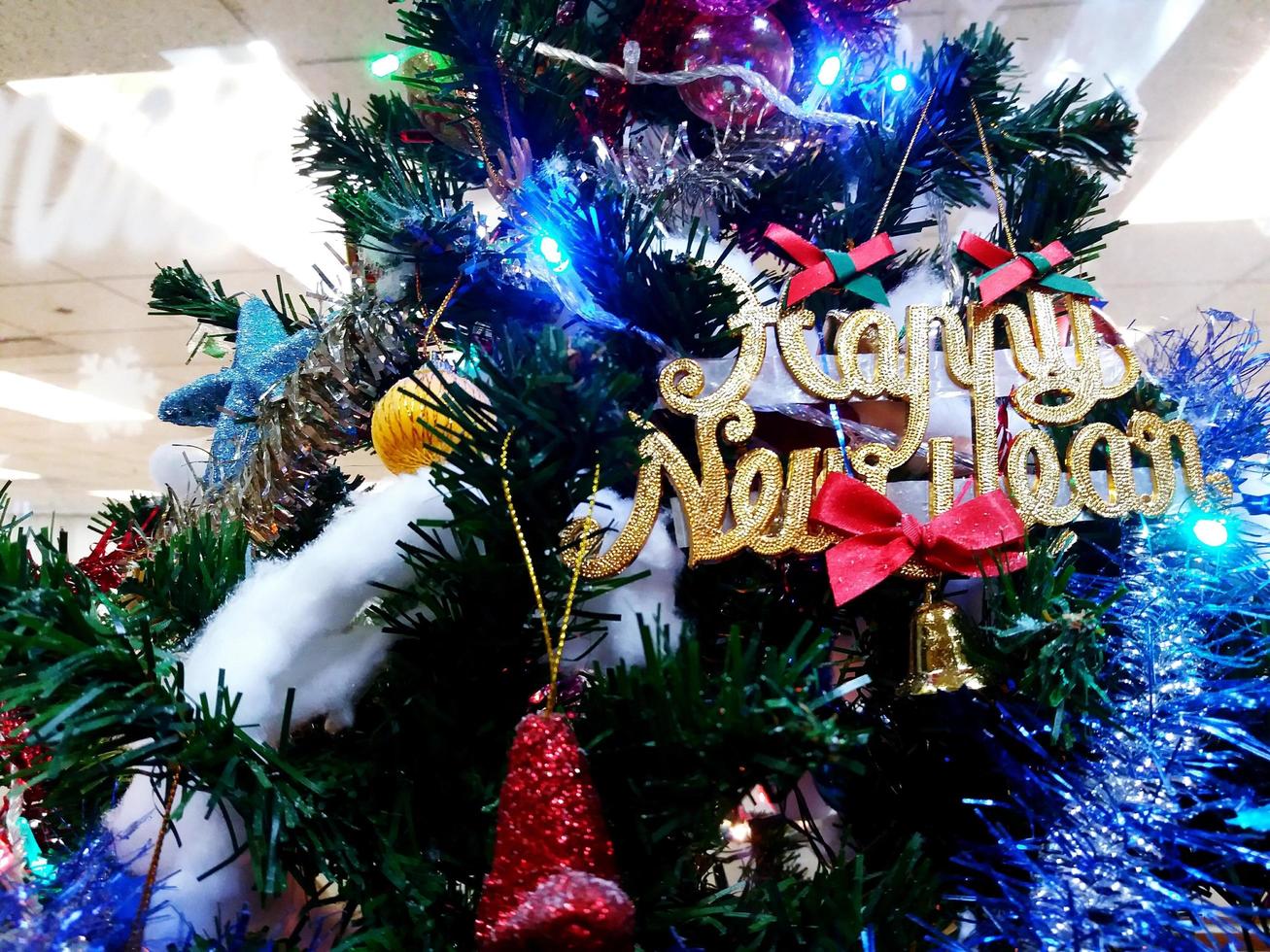 grüne weihnachten und frohes neues jahr baumschmuck mit blauem licht, goldener glocke und ball. foto