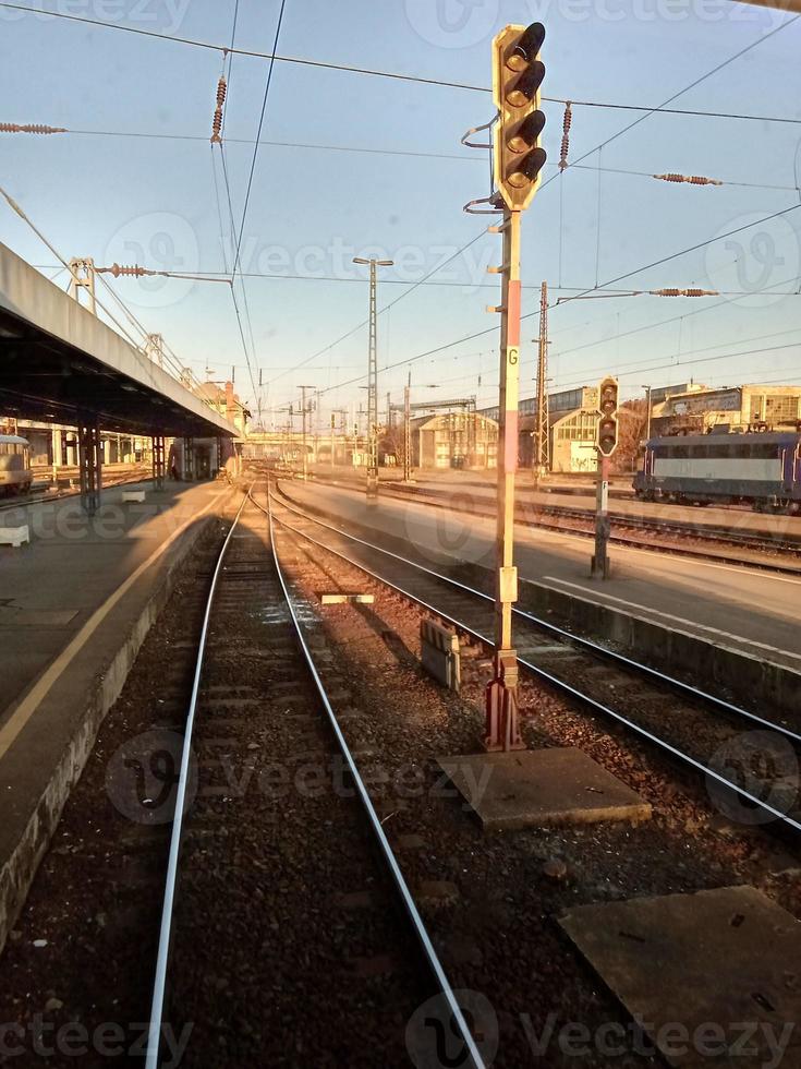 ein Zug, der Bahngleise in der Nähe eines Bahnhofs hinunterfährt foto