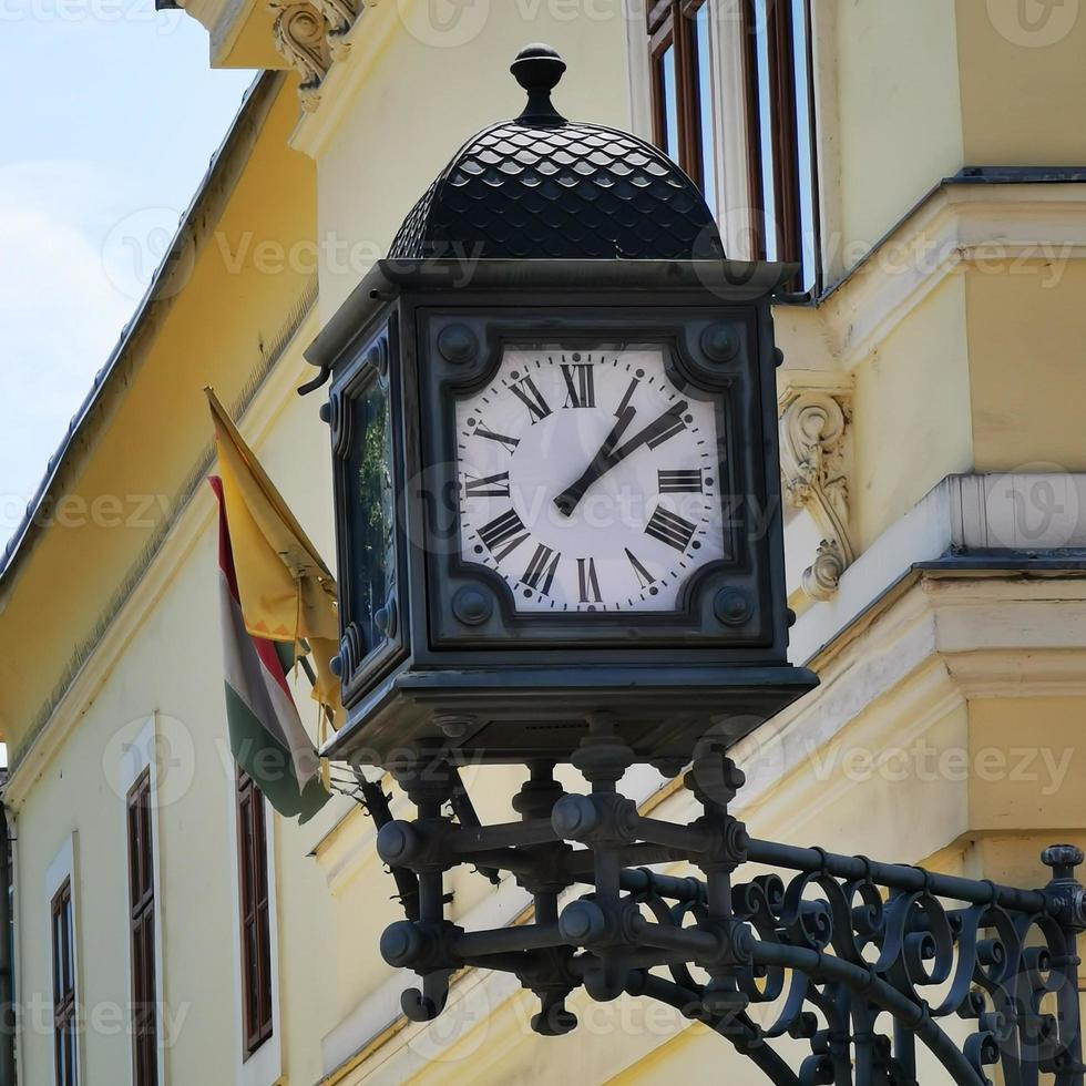 eine Uhr an der Seite eines Gebäudes foto