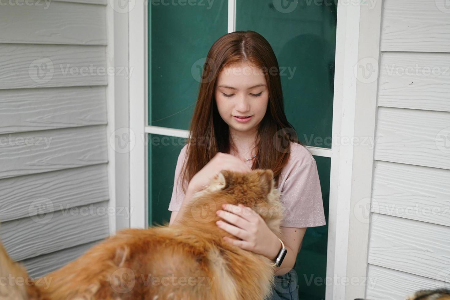 junges Mädchen in Freizeitkleidung, das Golden Retriever umarmt, während es auf dem Boden sitzt foto