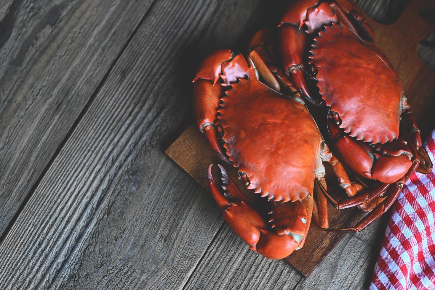 frische Krabben auf Holzschneidebrett, Meeresfrüchtekrabben, die in der Küche des Meeresfrüchterestaurants gekochte oder gedämpfte Krabben rot kochen foto