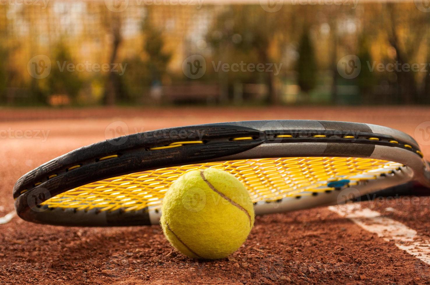 Tenniskonzept mit Schläger und Ball auf Sandplatz foto