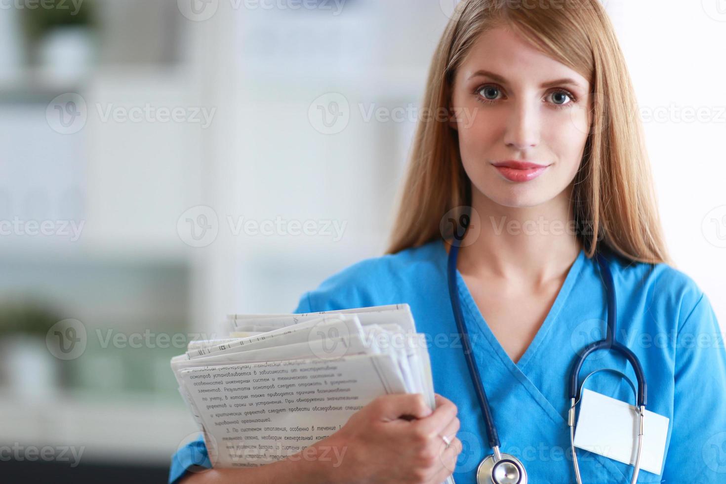 Porträt der Ärztin mit Ordner am Krankenhauskorridor foto