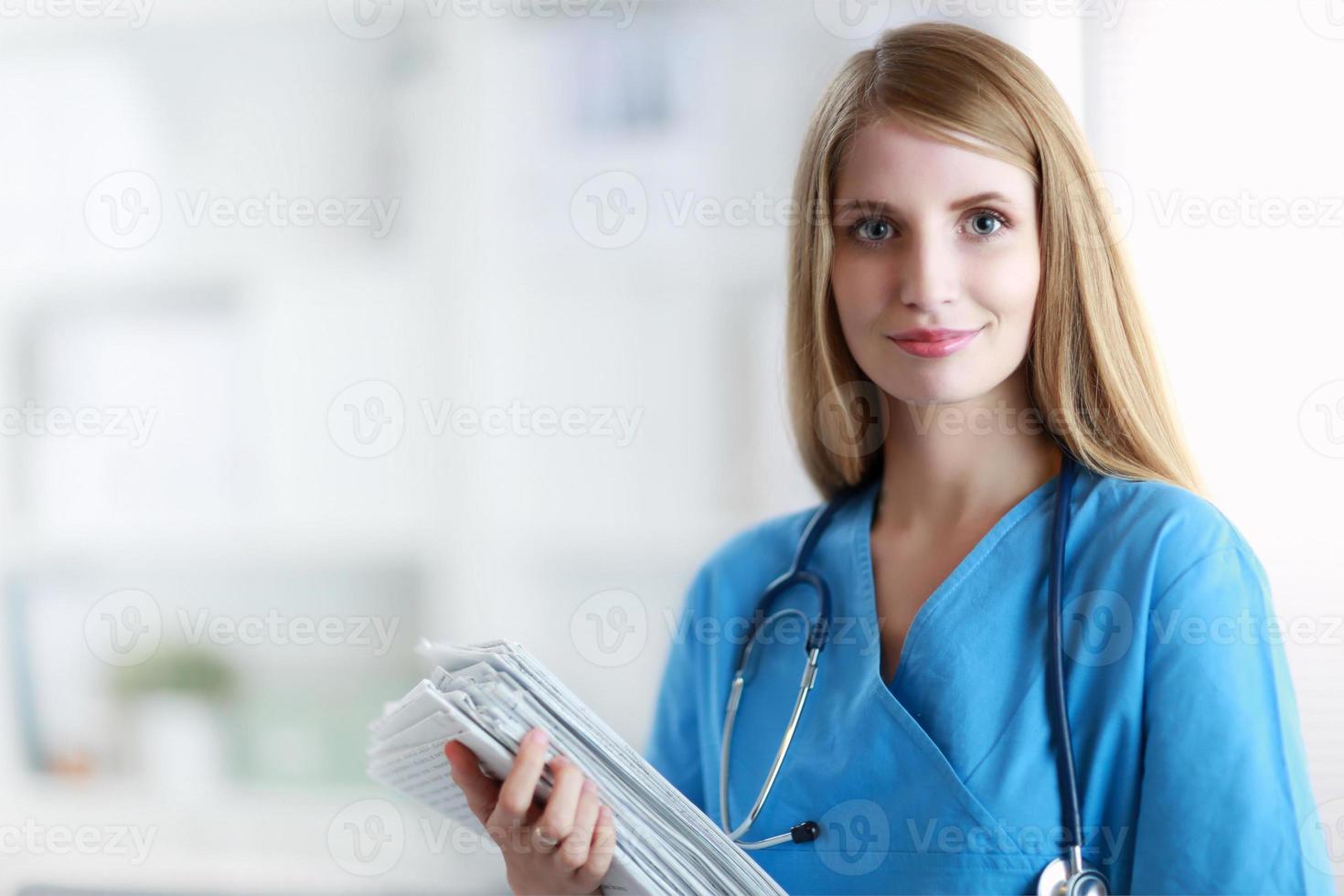 Porträt der Ärztin mit Ordner am Krankenhauskorridor foto