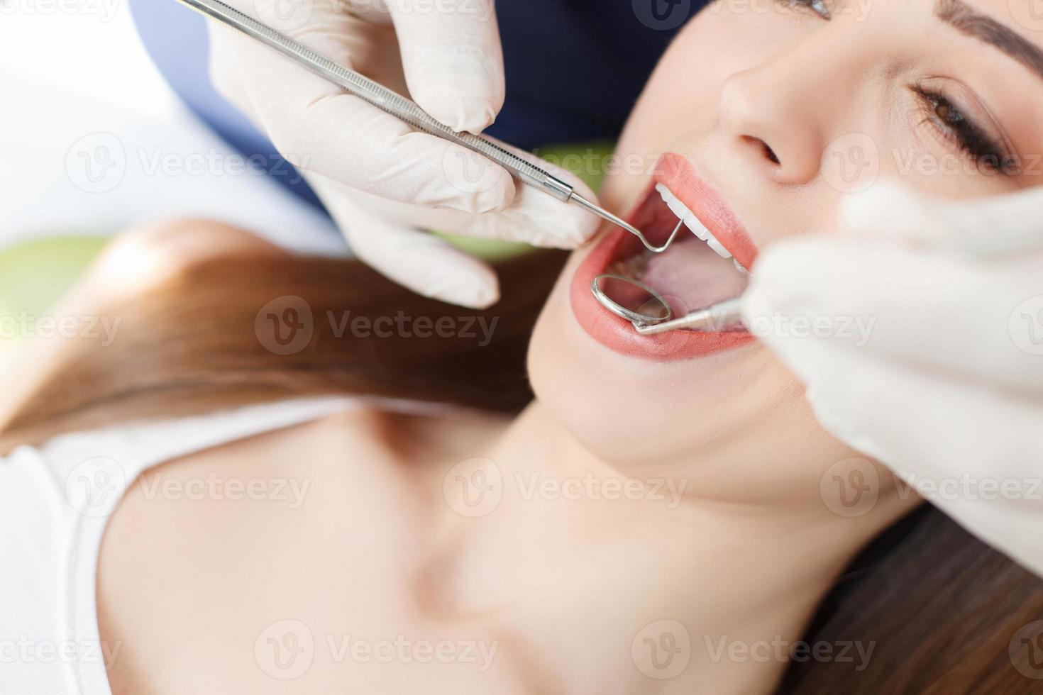 qualifizierter junger Zahnarzt behandelt weibliche Gesundheit foto