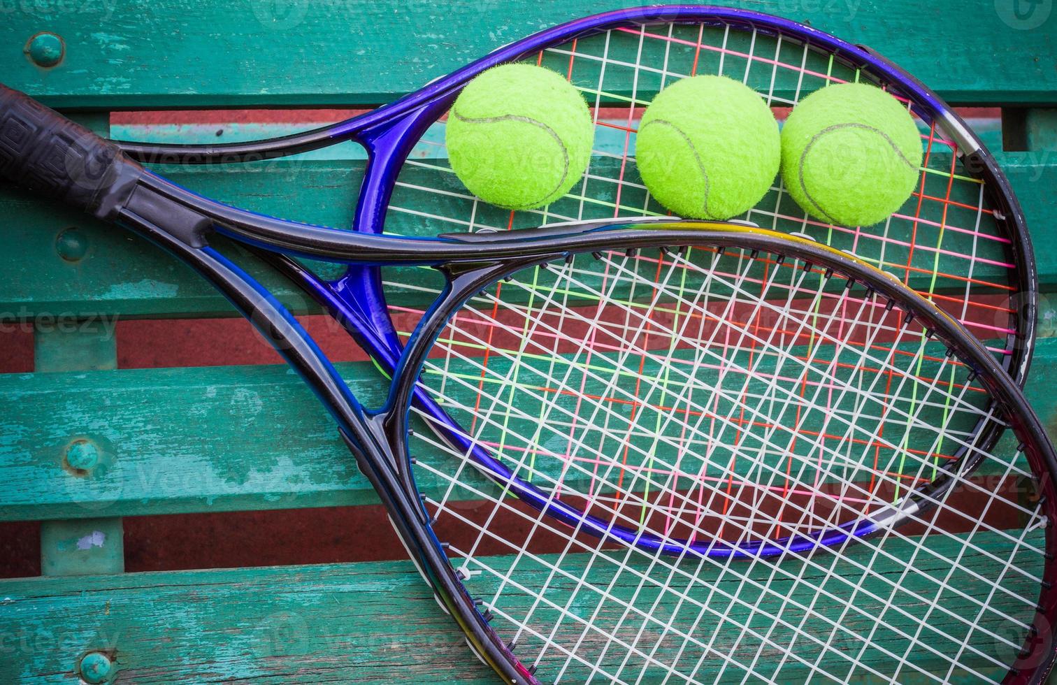 Tennisschläger mit Bällen auf Tennisplatz foto