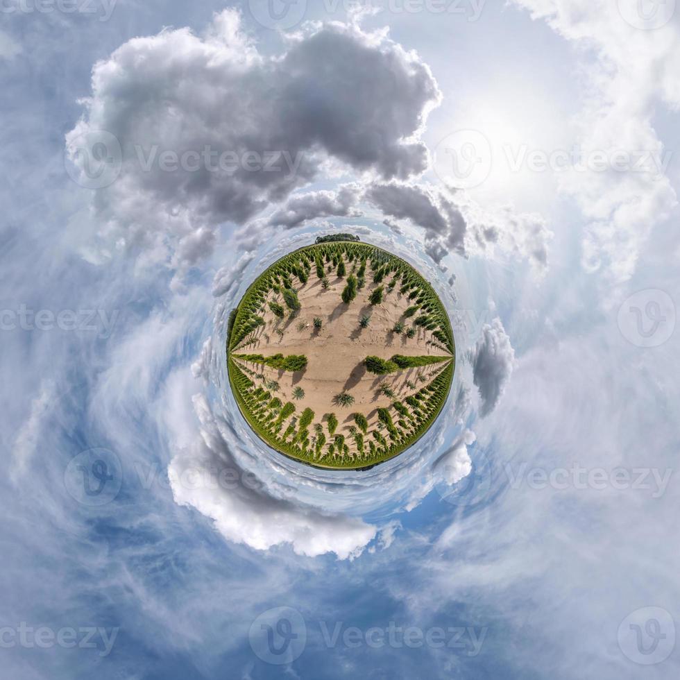 kleiner Planet im blauen Himmel mit Sonne und schönen Wolken. Transformation des sphärischen Panoramas 360 Grad. sphärische abstrakte Luftaufnahme. Krümmung des Raumes. foto