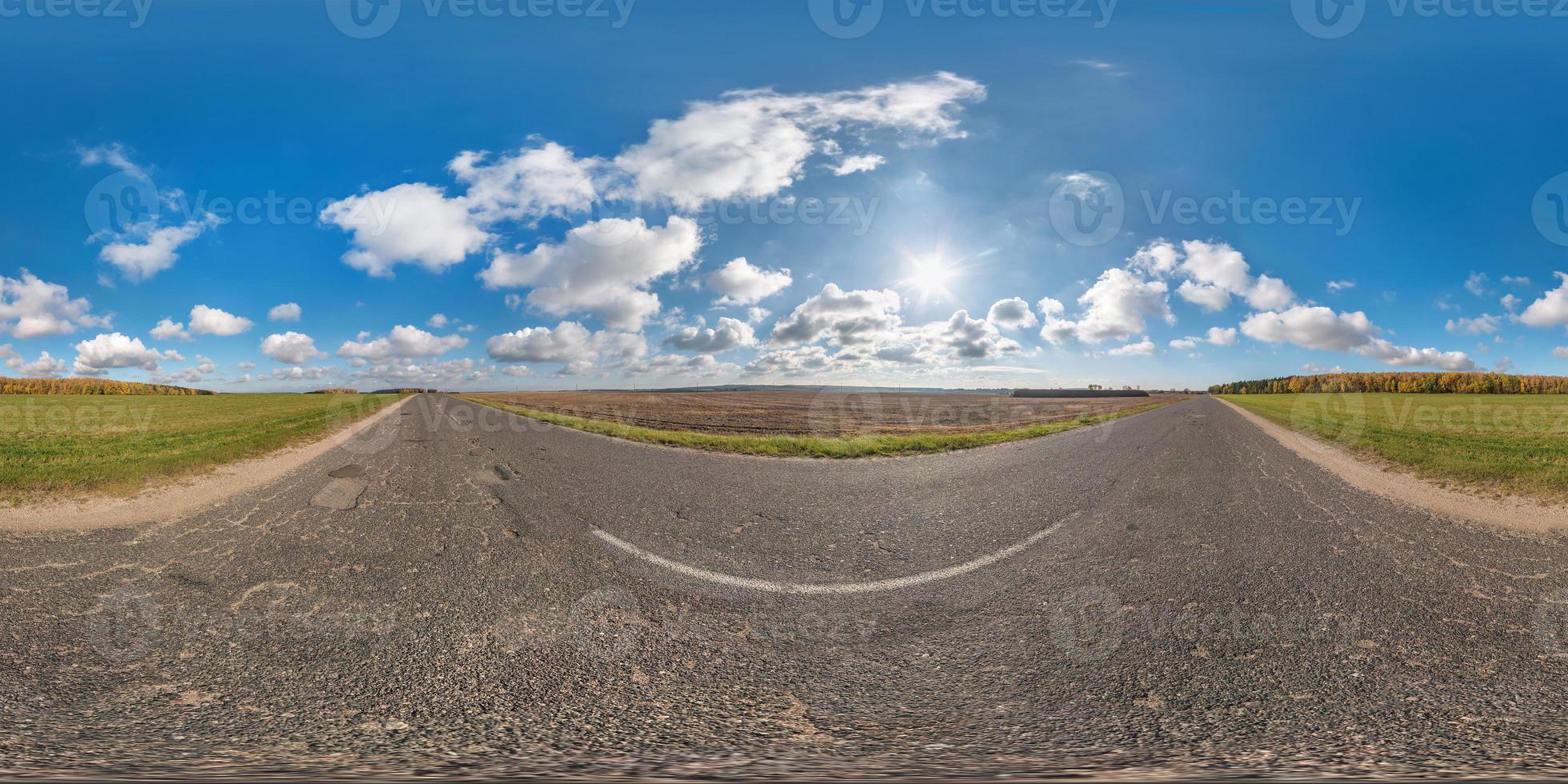 volles kugelförmiges nahtloses Panorama 360-Grad-Winkelansicht auf verkehrsfreier Asphaltstraße zwischen Feldern an sonnigen Tagen mit fantastischen Wolken. 360-Grad-Panorama in equirectangulärer äquidistanter Projektion, vr ar-Inhalt foto