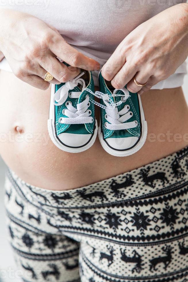 schwangerer Bauch mit Hausschuhen foto