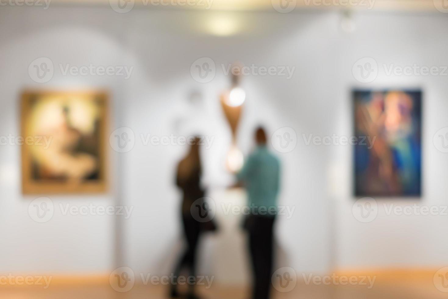 Zwei Frauen betrachten Gemälde im Museum, defokussiertes Bild. foto