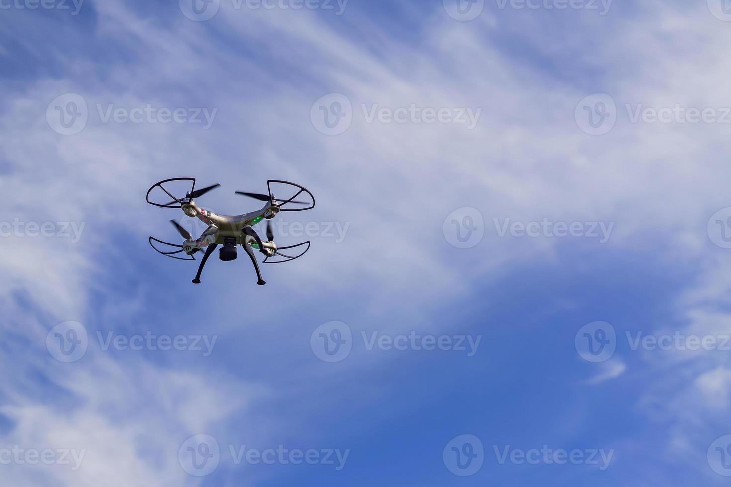 fliegende Drohne mit Fernbedienung vor blauem Himmelshintergrund. foto