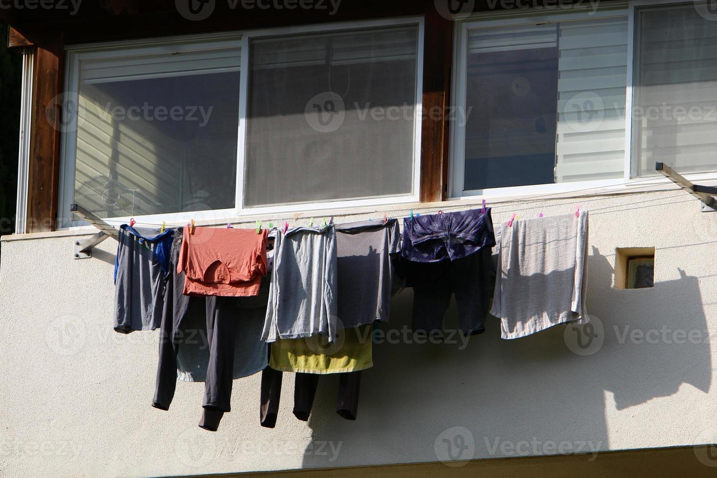 Gewaschene Wäsche trocknet auf der Straße vor dem Fenster des Hauses. foto