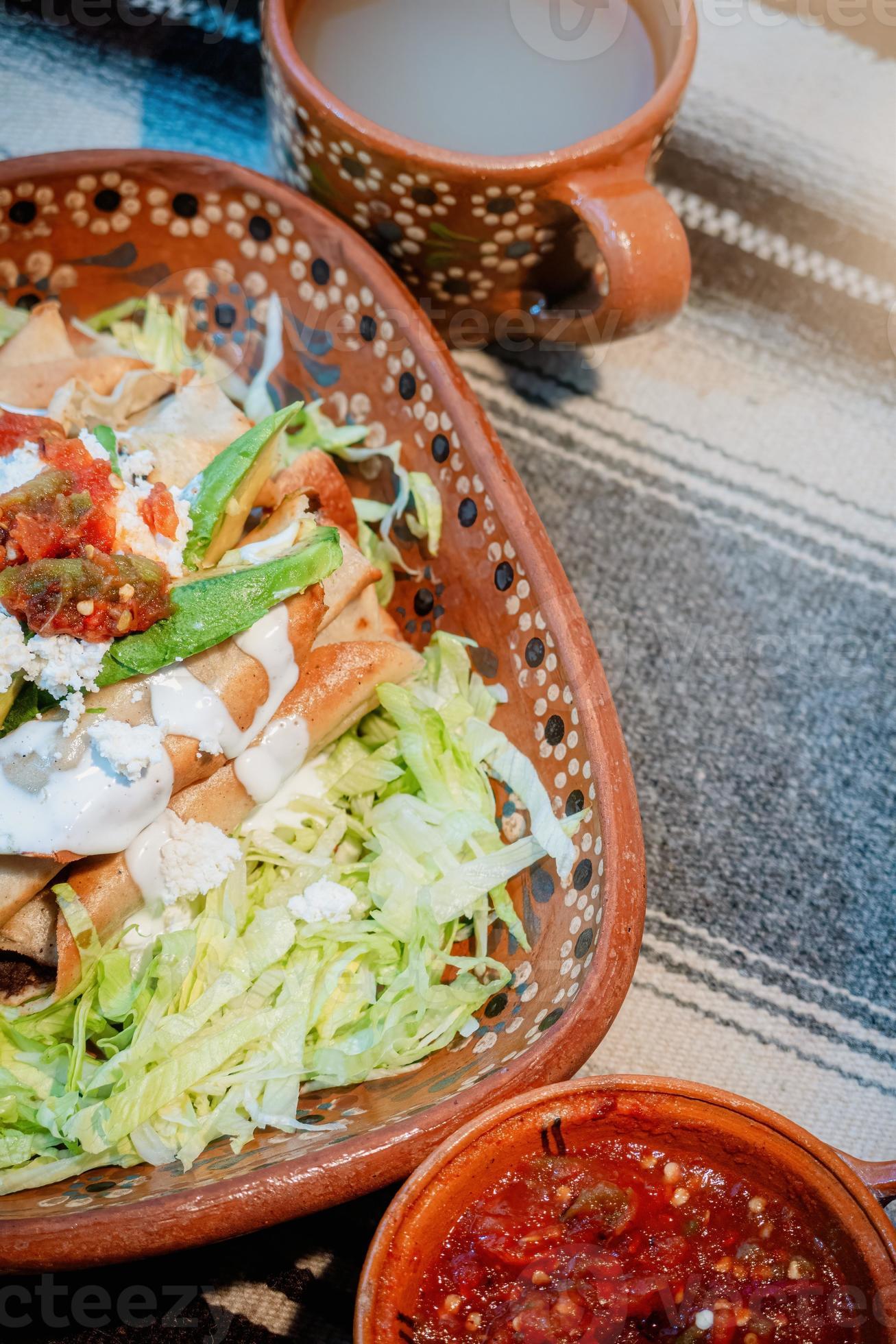 mexikanische Flautas mit Salat, Avocado, Sahne, Sauce und frischem ...