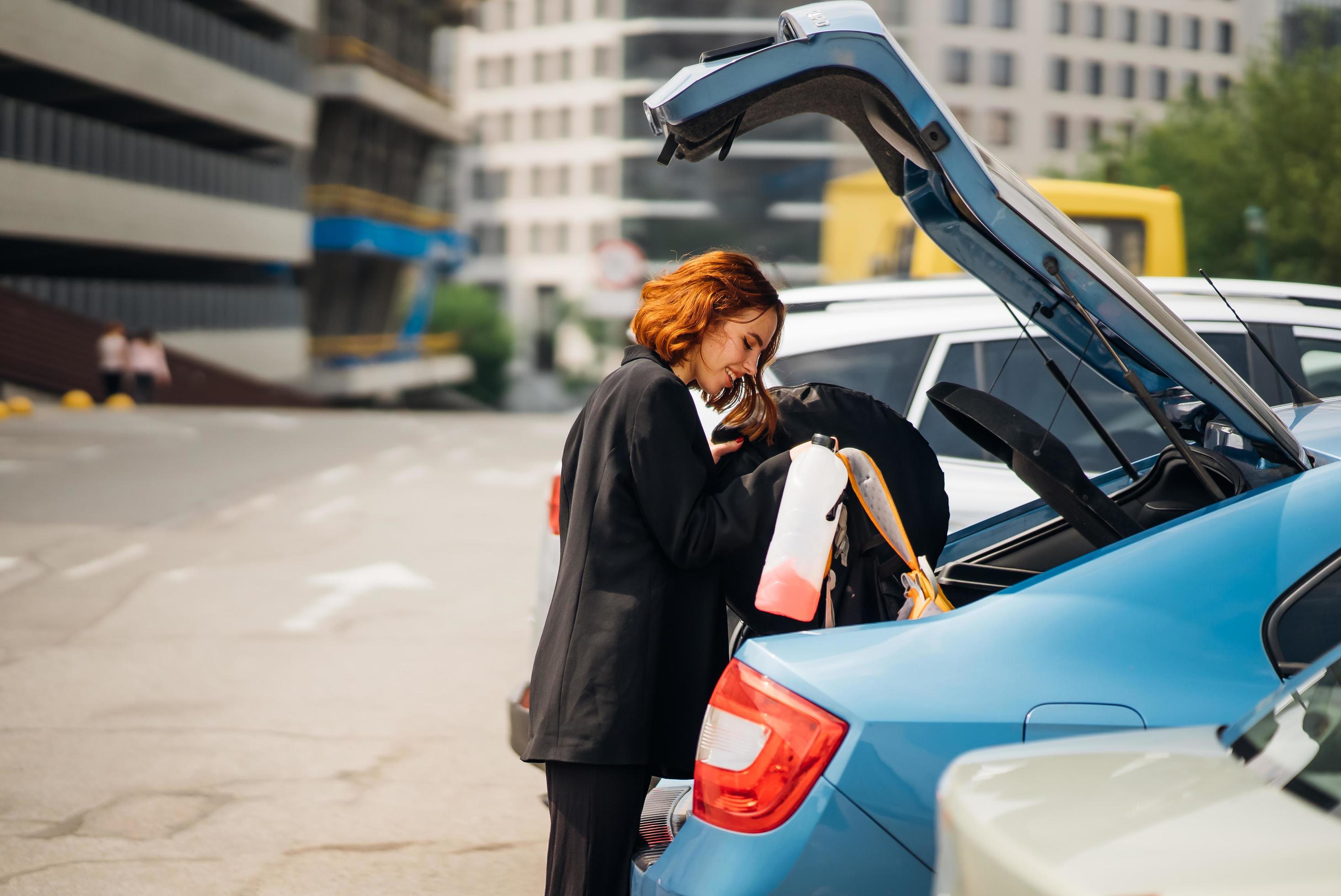 Eine Frau legt Sachen ins Auto 13637528 Stock-Photo bei Vecteezy