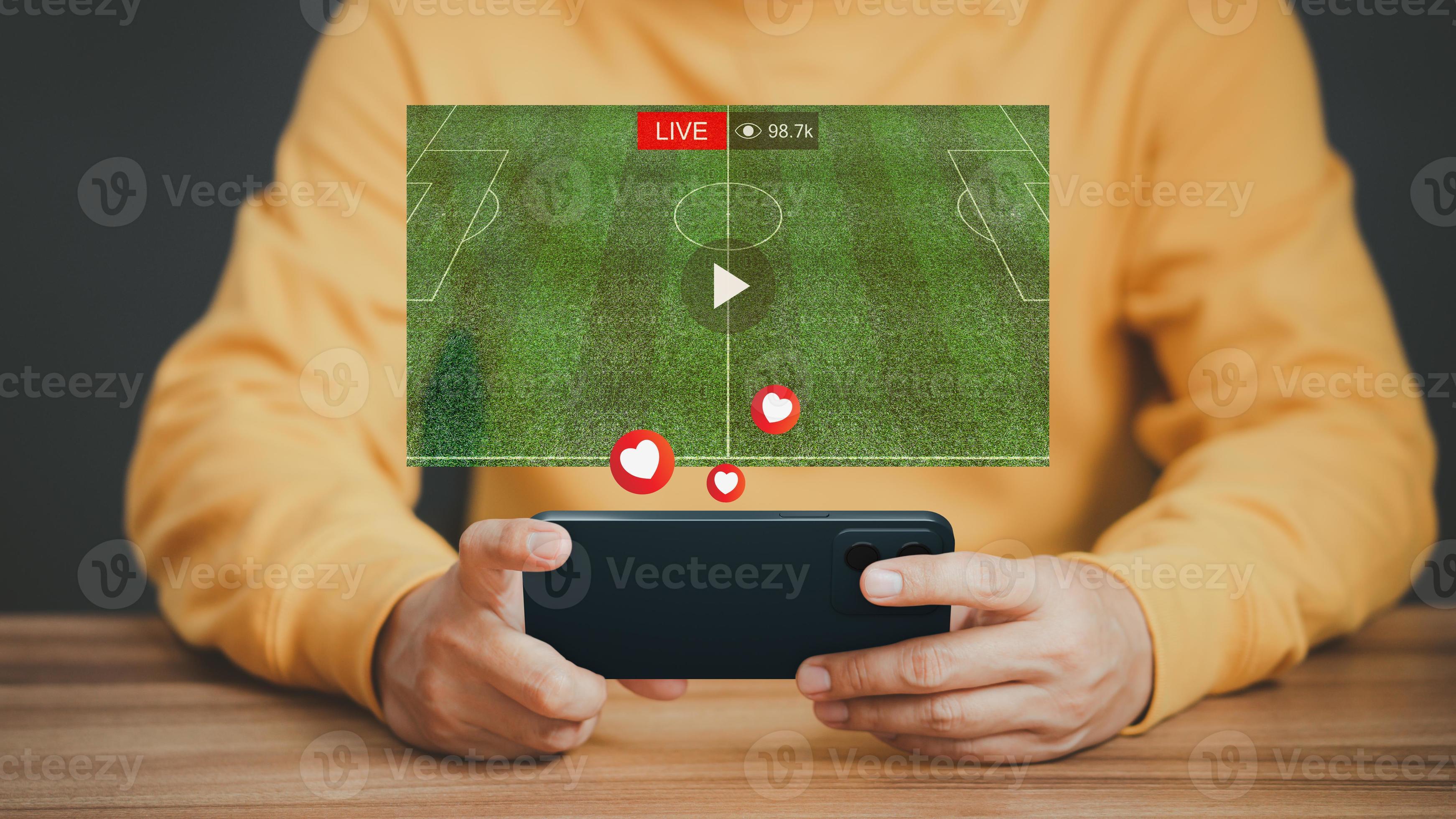 Mann, der ein Smartphone oder Mobiltelefon verwendet, um Live-Fußball-Streaming online auf einem virtuellen Bildschirm zu sehen, Videos im Internet zu durchsuchen, Konzept der Online-Inhalte