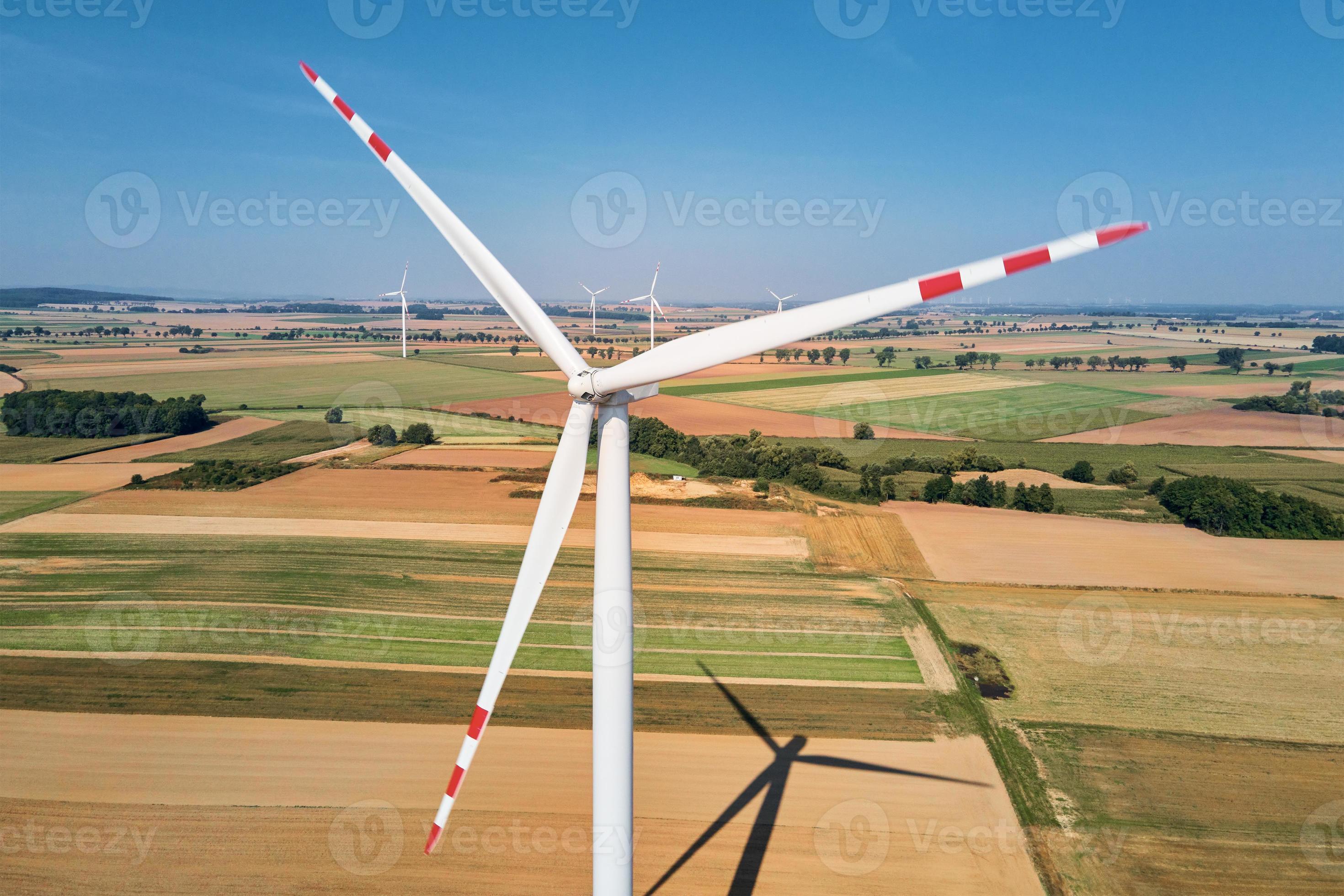 windmühlenturbine im feld am sommertag. drehender Windgenerator