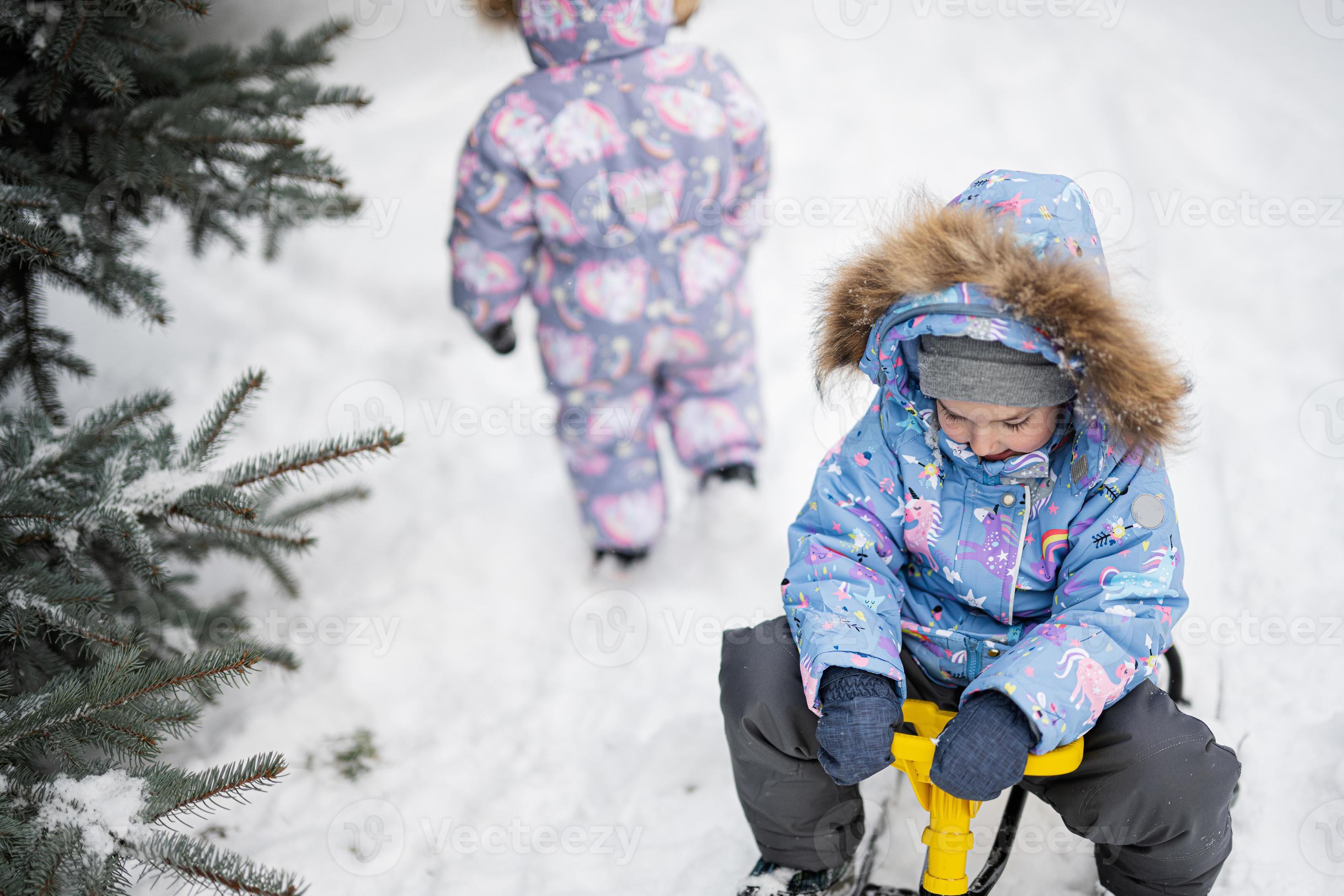 kinder spielen draußen im schnee. Zwei kleine Schwestern genießen