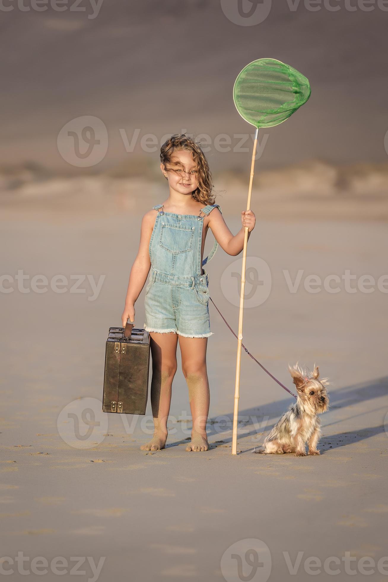 Mädchen mit Koffer und Scoop Netz Stehen in der Nähe von Hund auf Strand  19987102 Stock-Photo bei Vecteezy