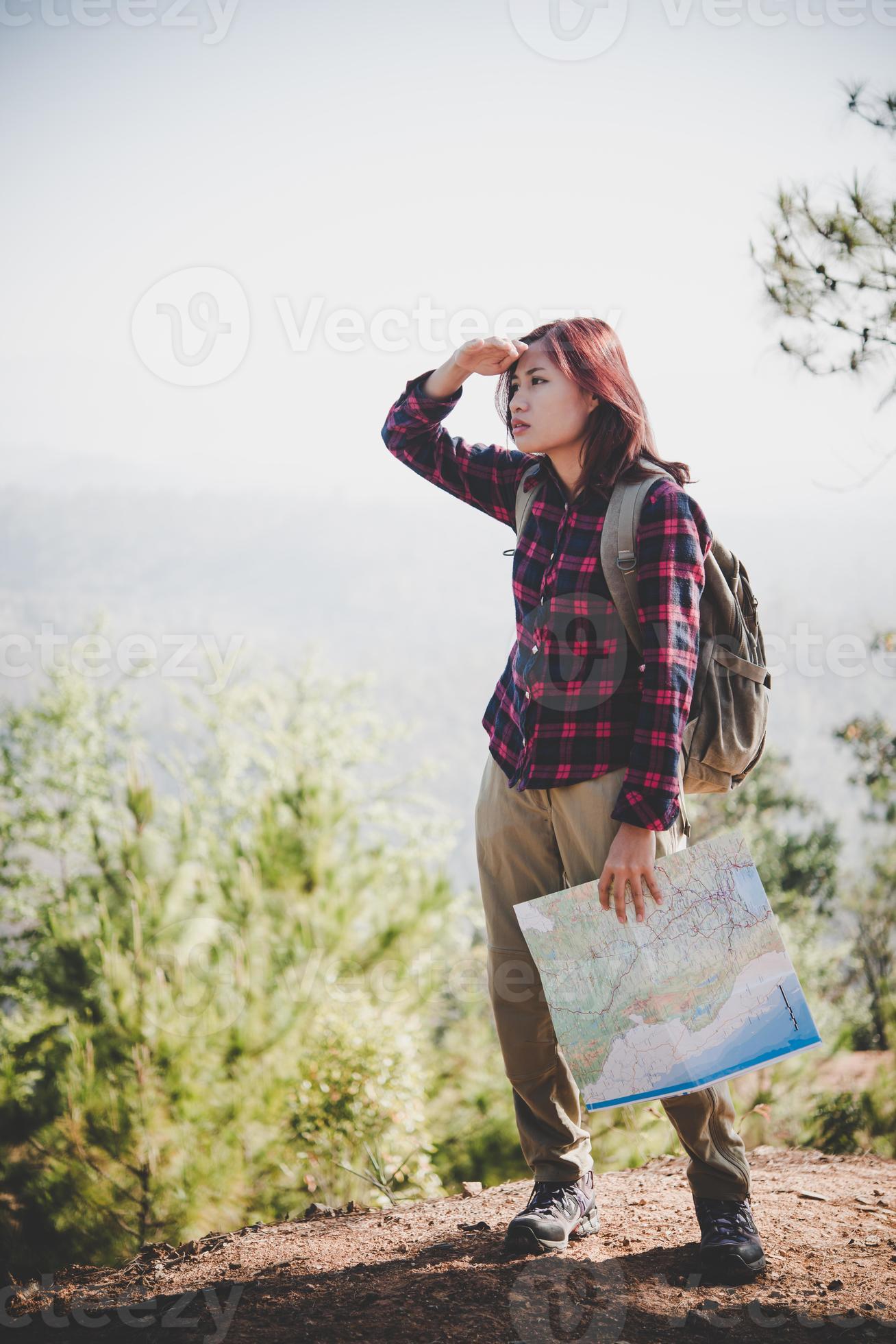 Reisemädchen, das auf der Karte nach der richtigen Richtung sucht, während der Berg wandert foto