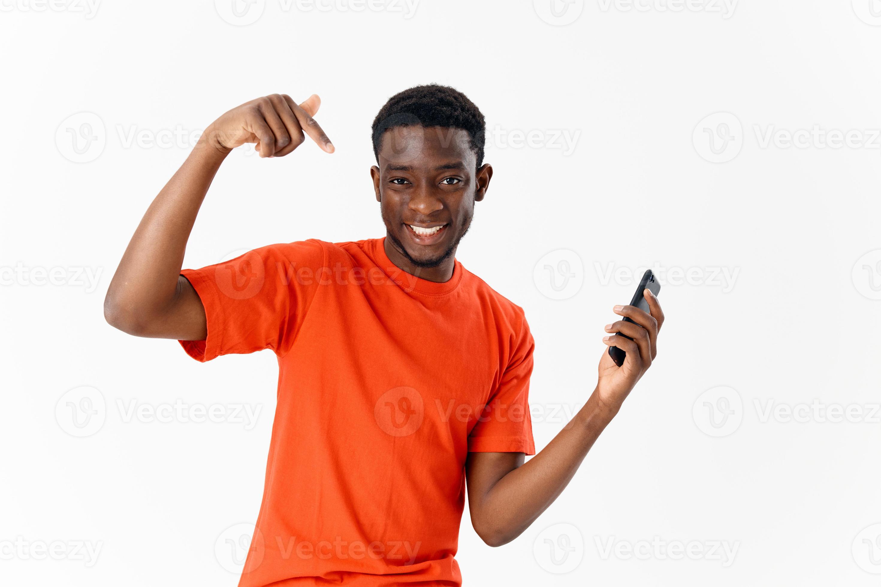 heiter Mann von afrikanisch Aussehen mit ein Telefon im seine Hände  gestikulieren mit ein Finger Licht Hintergrund 22064916 Stock-Photo bei  Vecteezy