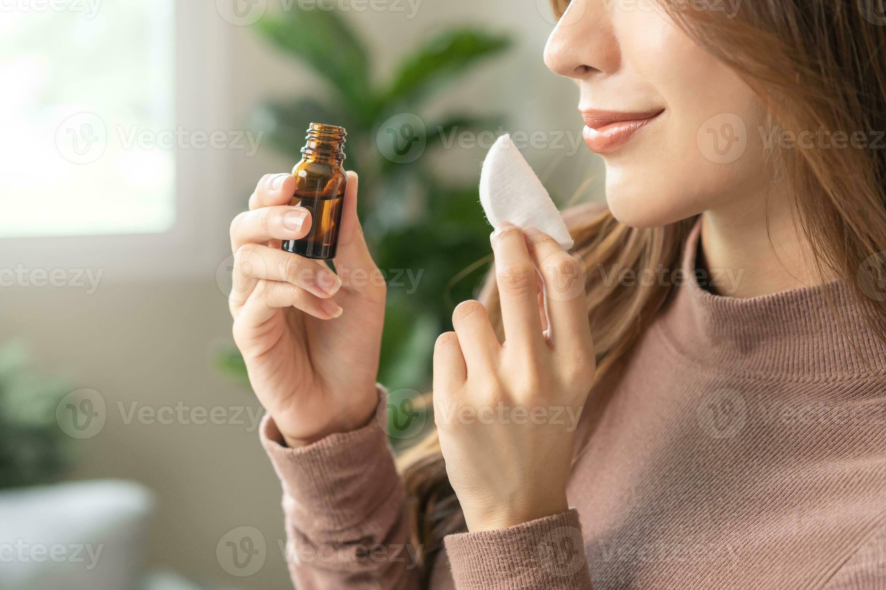 Aromatherapie, asiatisch jung Frau Hand halten Baumwolle Pad, Flasche von  wesentlich Parfüm Öl, genießen Geruch Duft von Kräuter- von Medizin  natürlich organisch beim heim. Therapie Behandlung, Schönheit Haut Pflege.  25133442 Stock-Photo bei