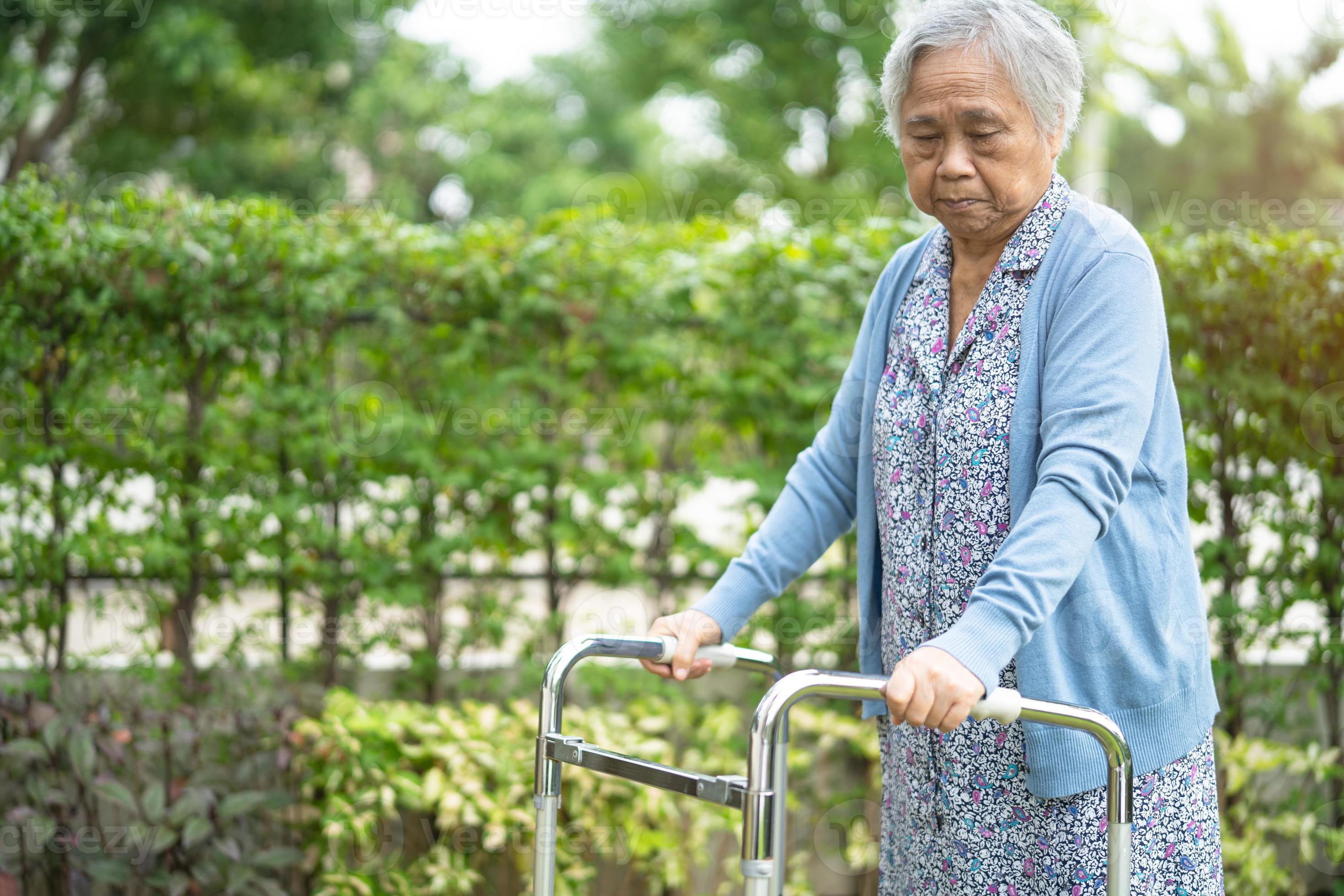 Asiatische Senioren oder ältere alte Damenfrauen verwenden einen Walker mit starker Gesundheit, während sie im Park in einem schönen Urlaub spazieren gehen foto