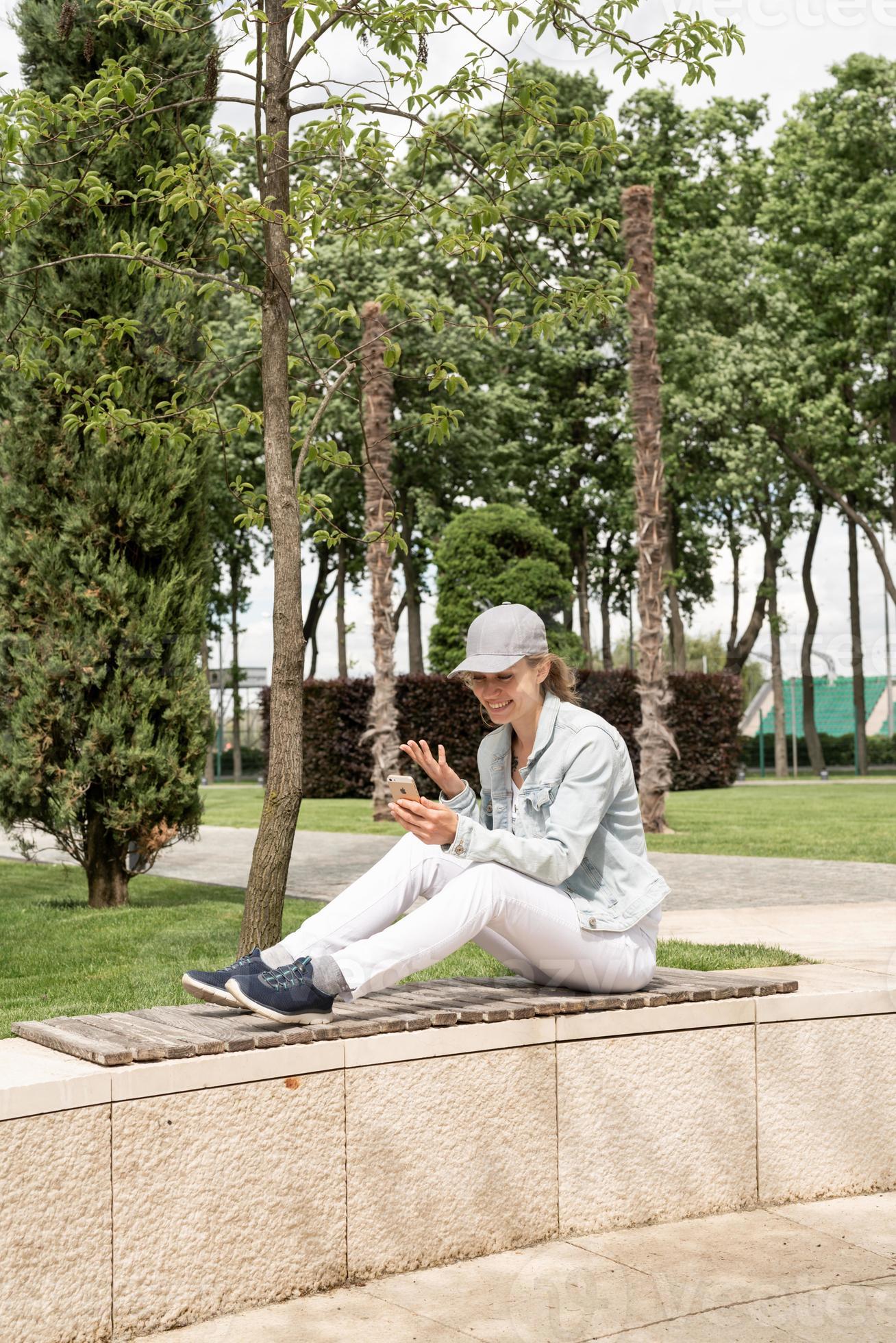 Frau im Freien macht Selfie auf ihrem Handy foto