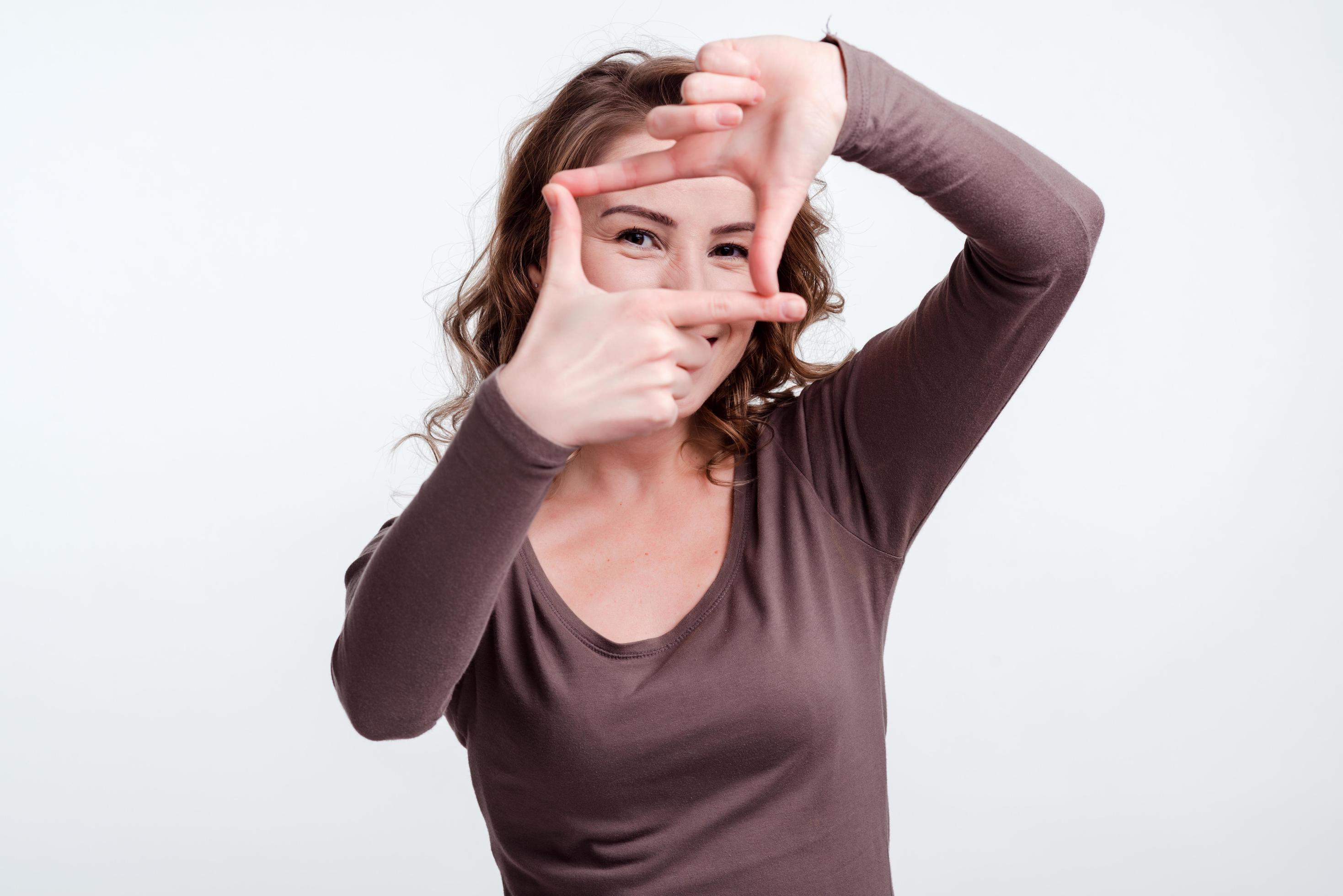 Mädchen machte einen rechteckigen Rahmen aus Fingern gegenüber ihren Augen foto