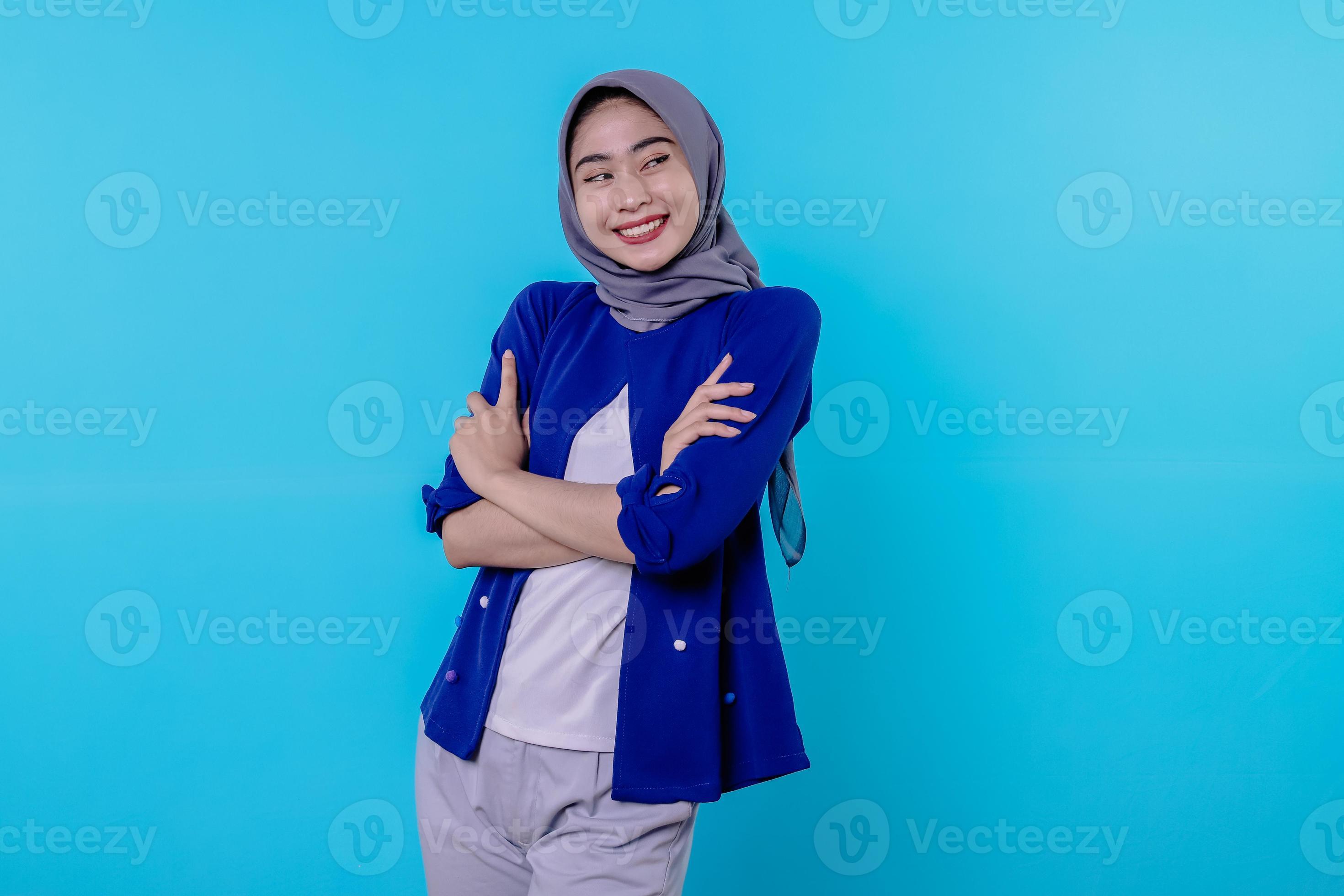 Optimistische charmante attraktive junge Frau mit süßem Lächeln freudig mit schönem weißem Lächeln auf hellblauem Hintergrund foto