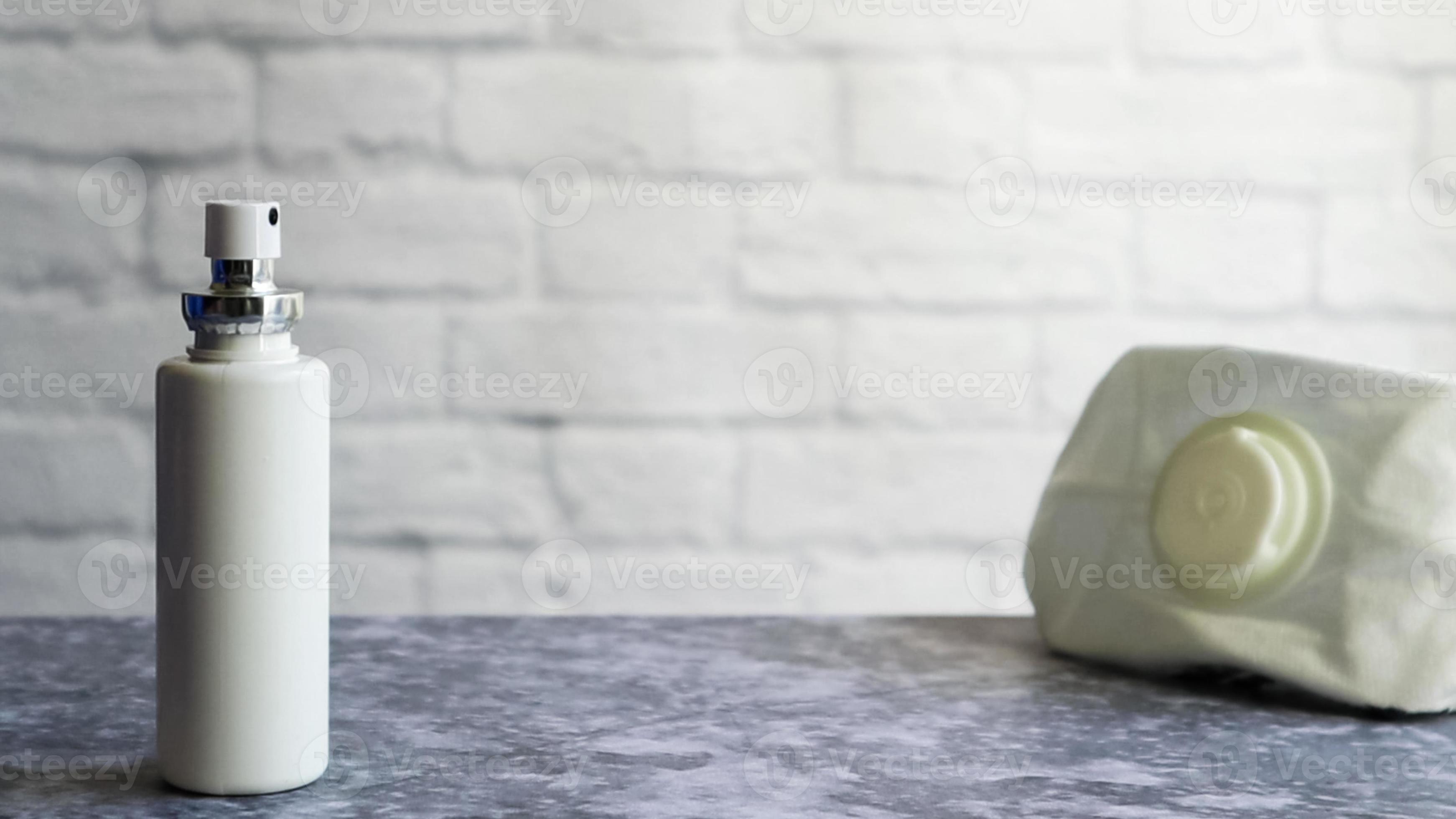 weiße antiseptische Flasche und eine Maske eines Schutzmittels auf einem grauen Tisch, auf dem Hintergrund einer weißen Ziegelwand. Prävention der Coronavirus-Krankheit Covid-19 während eines Ausbruchs des Influenzavirus foto