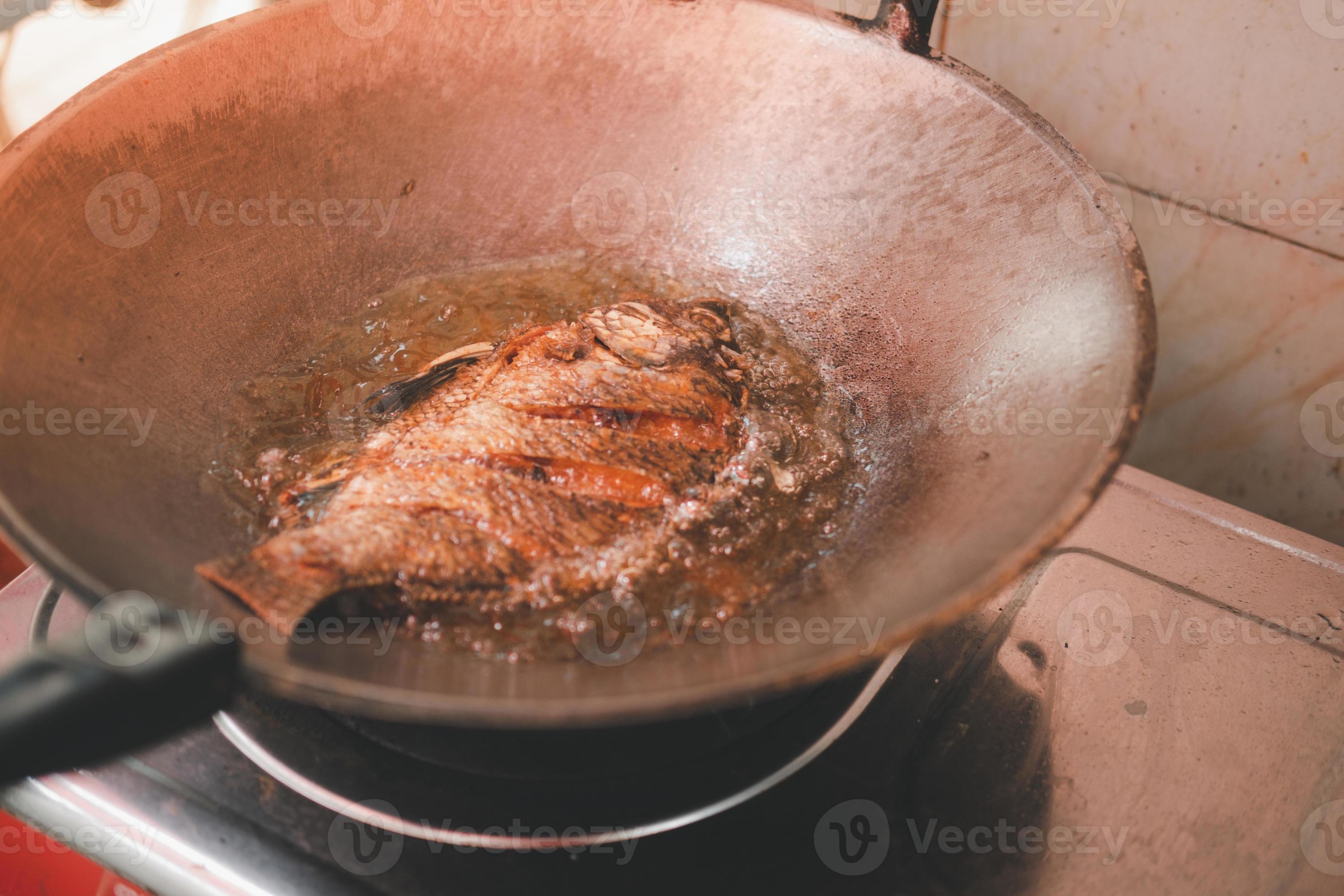 Gebratener Tilapia-Fisch in einer Pfanne mit heißem Öl 6000820 Stock ...