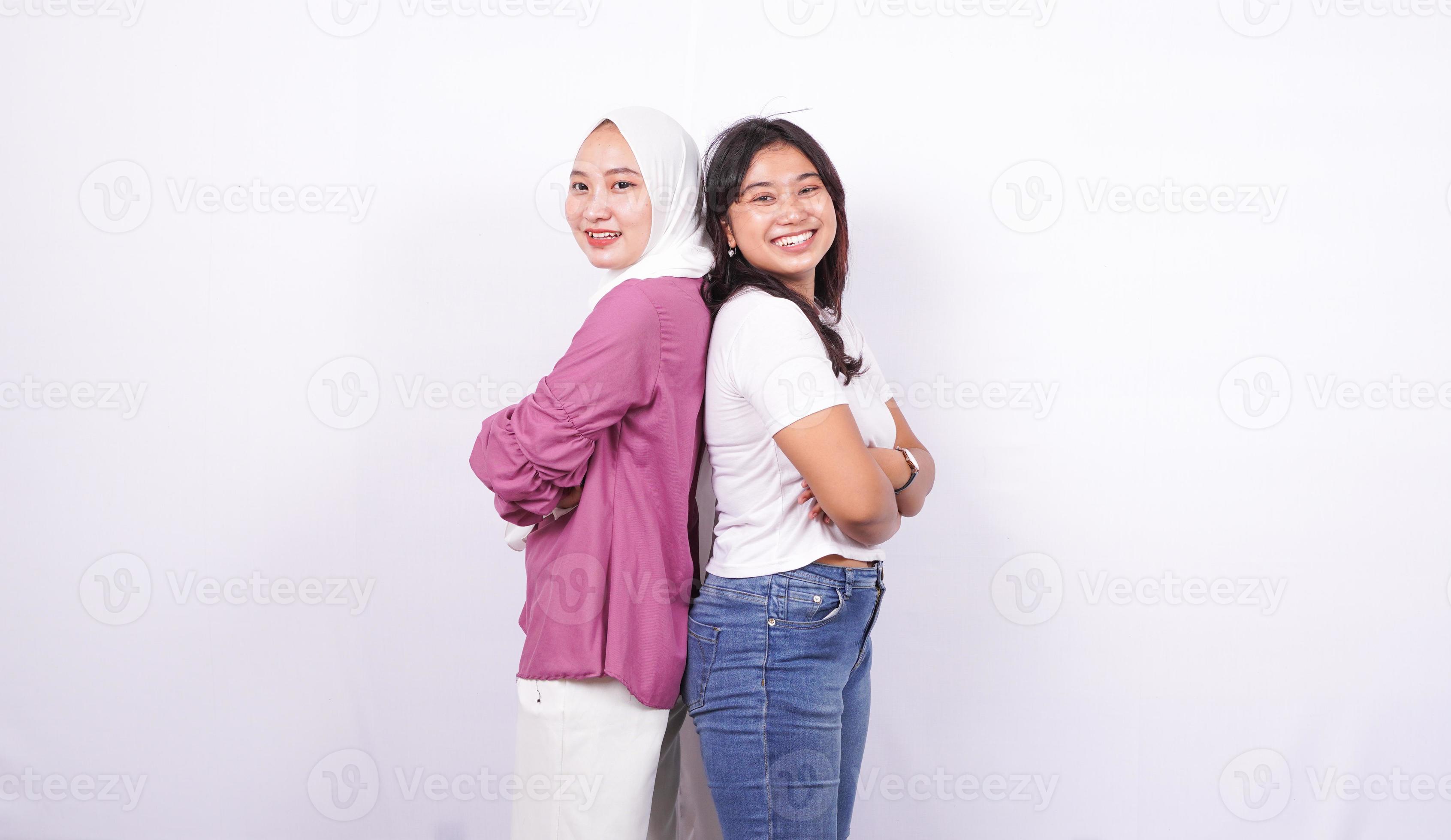 zwei asiatische Frauen, die glückliche Ausdrücke tun, lokalisierten weißen Hintergrund foto