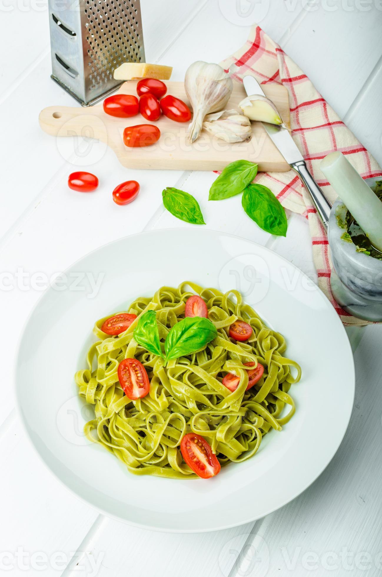 Spinat Tagliatelle mit Basilikum Pesto und Mini-Tomaten foto