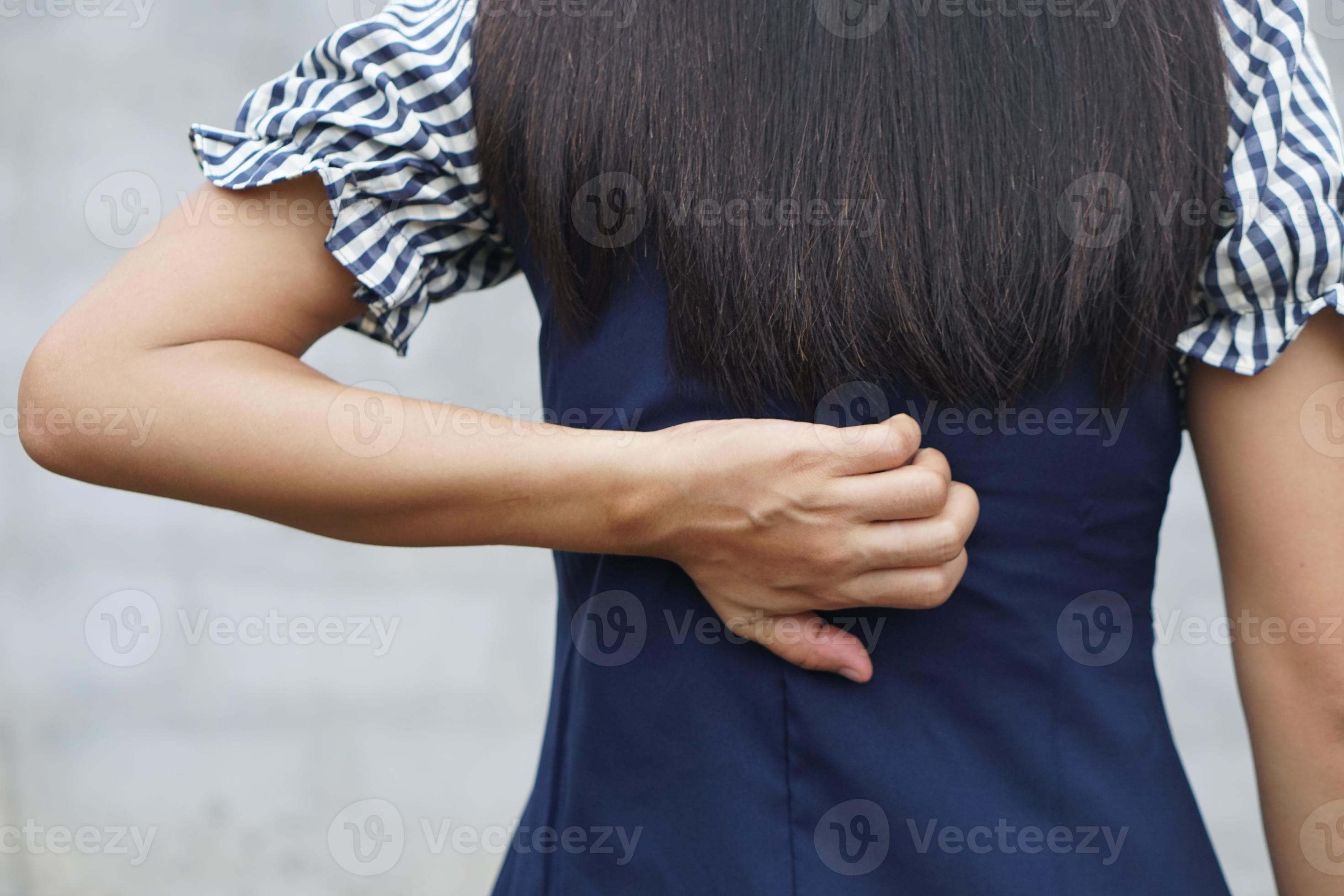 Rückseite der weißen Frau Rückenschmerzen und Schmerzkonzept, juckende asiatische Frau im Rücken foto