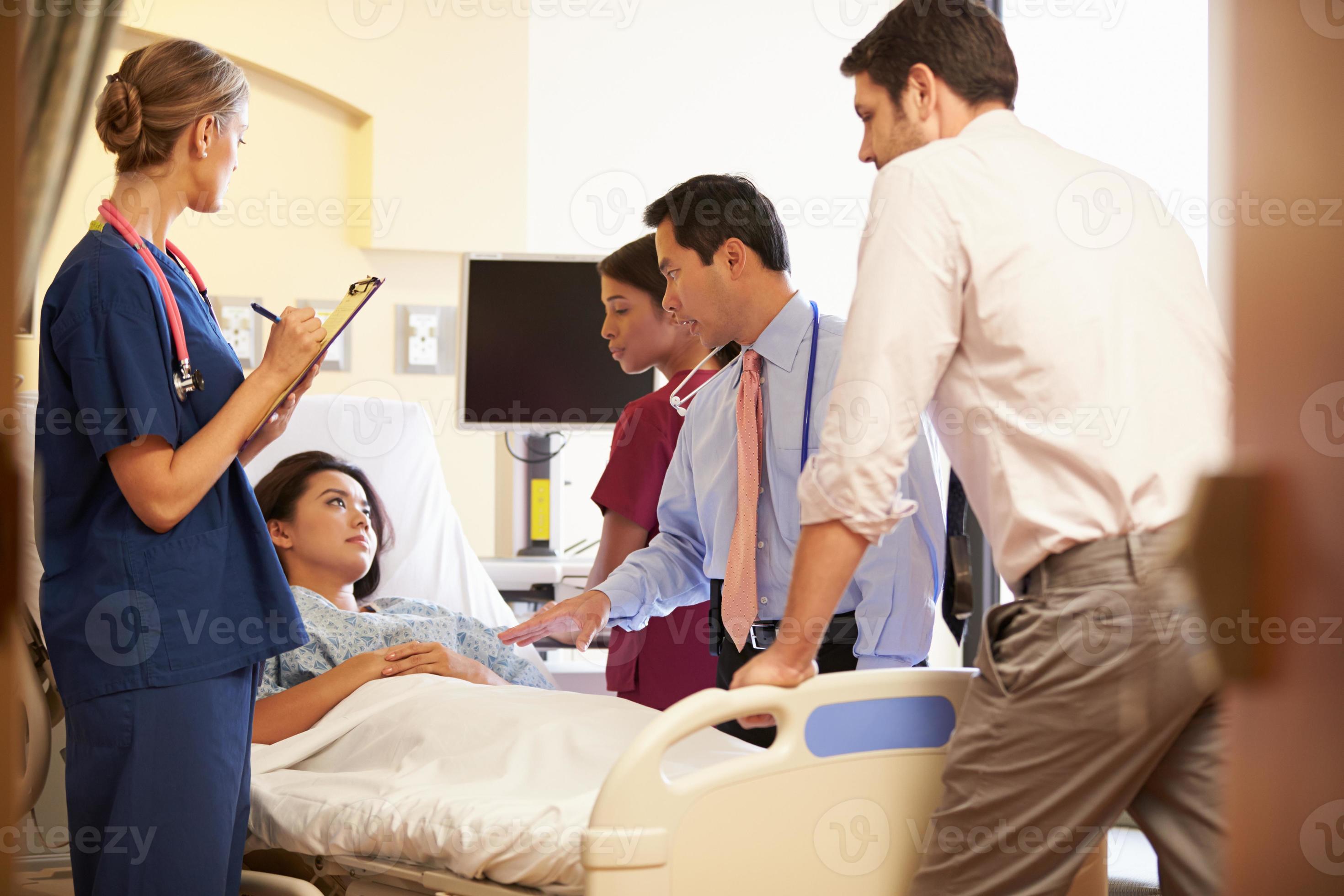 Mediziner neigen zu einer Patientin im Krankenhaus foto
