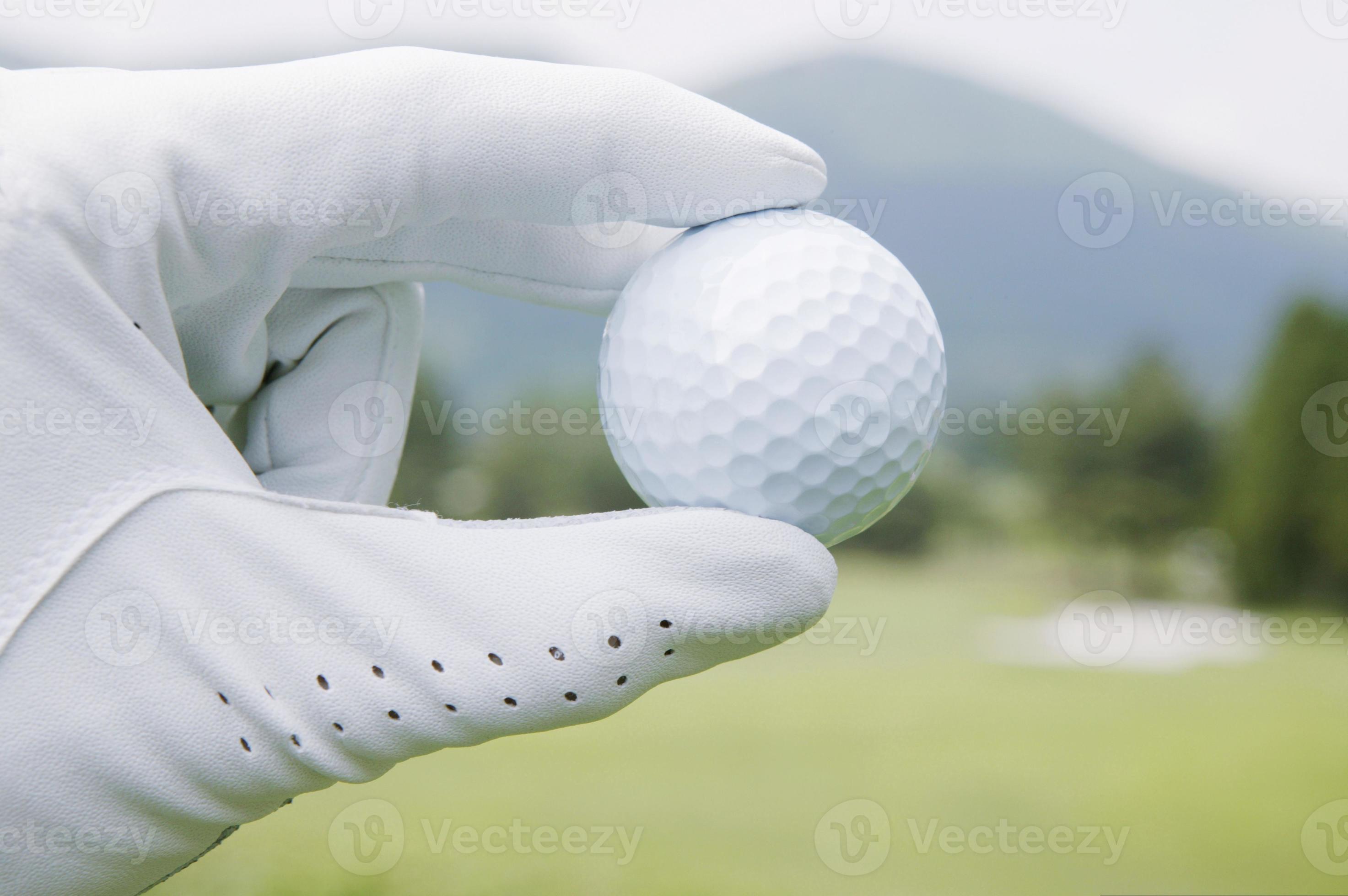 Golfball wird von behandschuhter Hand gehalten, Nahaufnahme foto