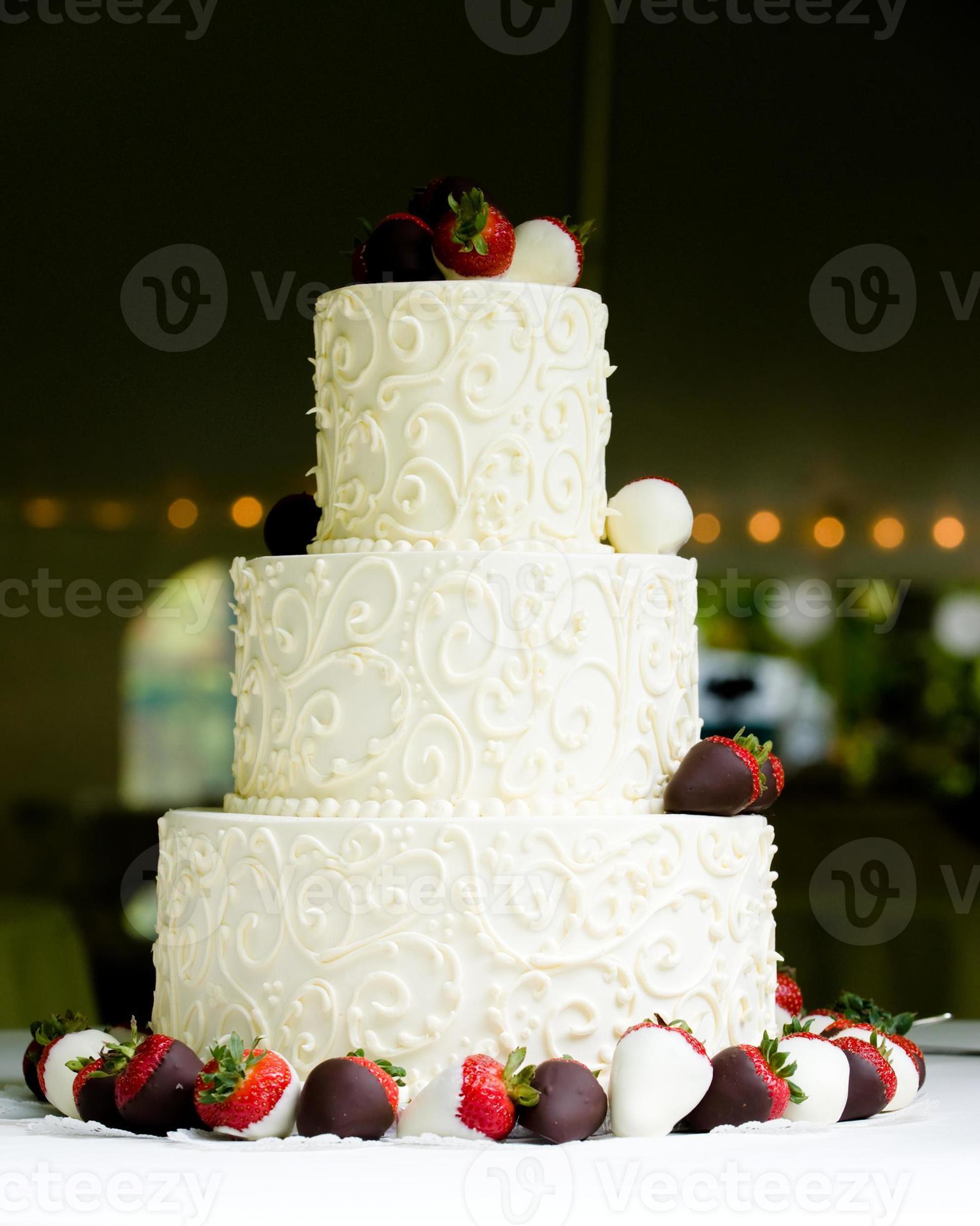 dreischichtige Hochzeitstorte mit Erdbeeren mit Schokoladenüberzug foto