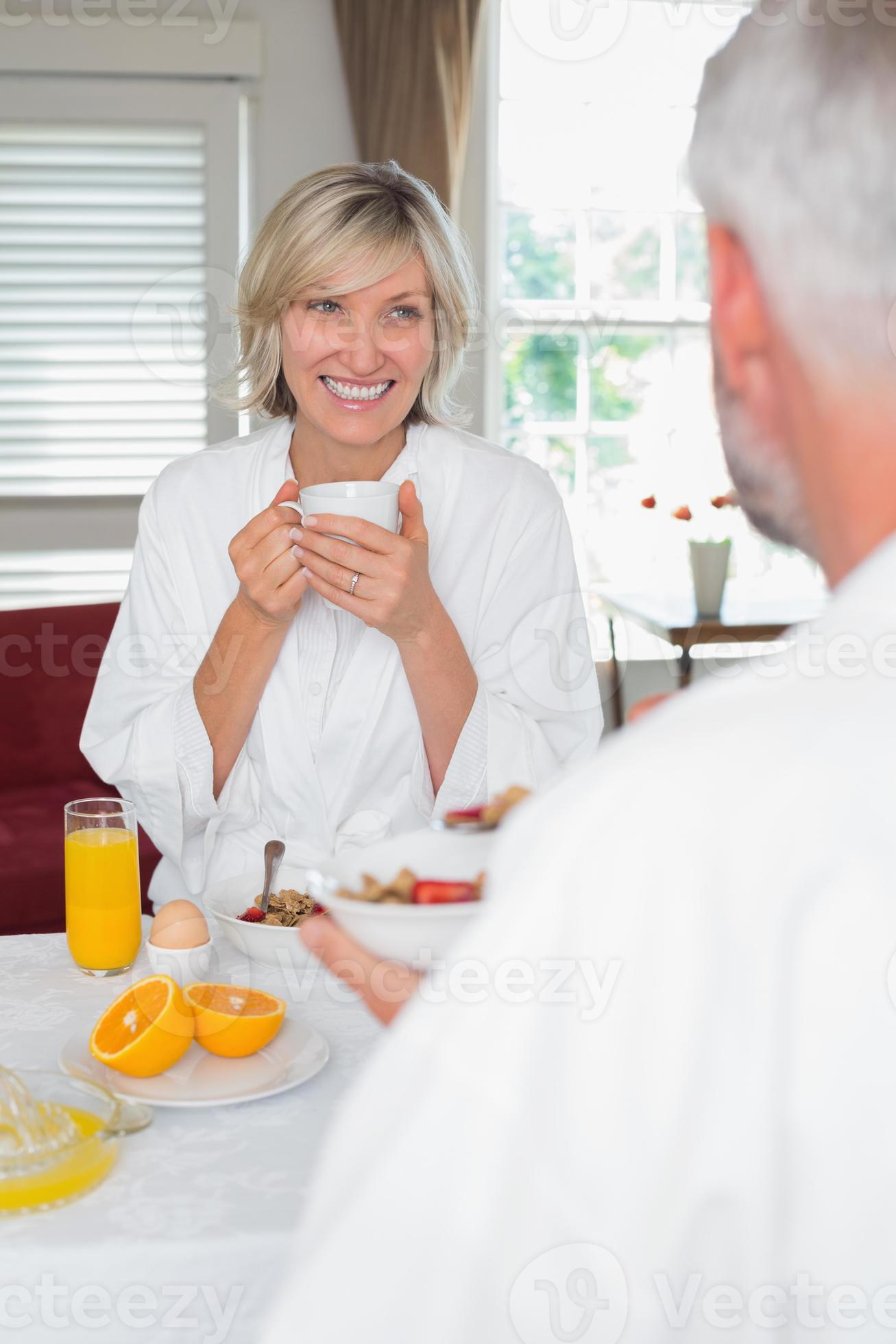 lächelnde reife Frau, die Frühstück mit abgeschnittenem Mann hat foto